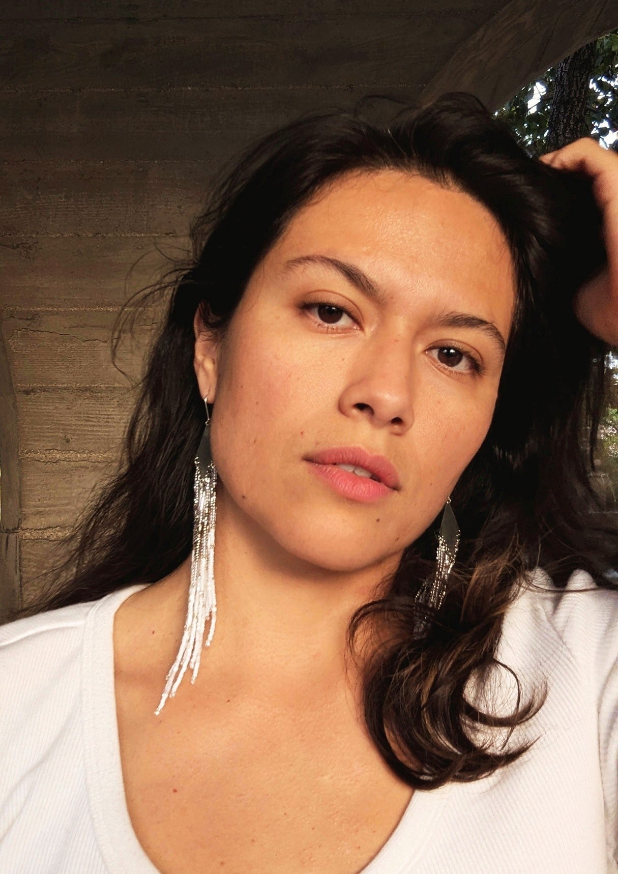 Handcrafted beaded earrings on a model with Czech beads, silver accents, and brass, featuring a delicate white and silver design for an artisan-crafted, textured look.