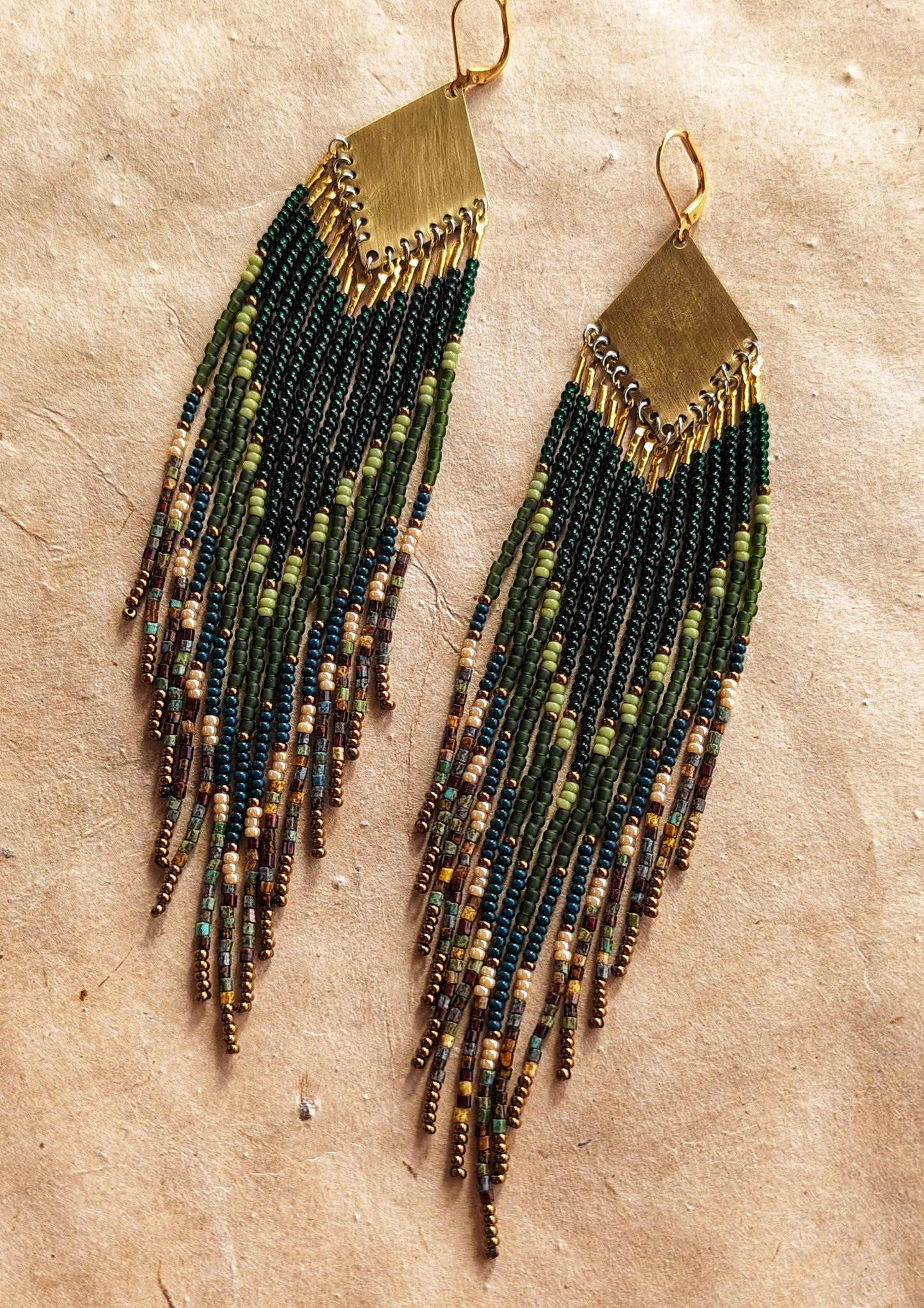 Long native beaded earrings by Moon & Milk in layered green, brown, and matte earthy tones with brass tops.