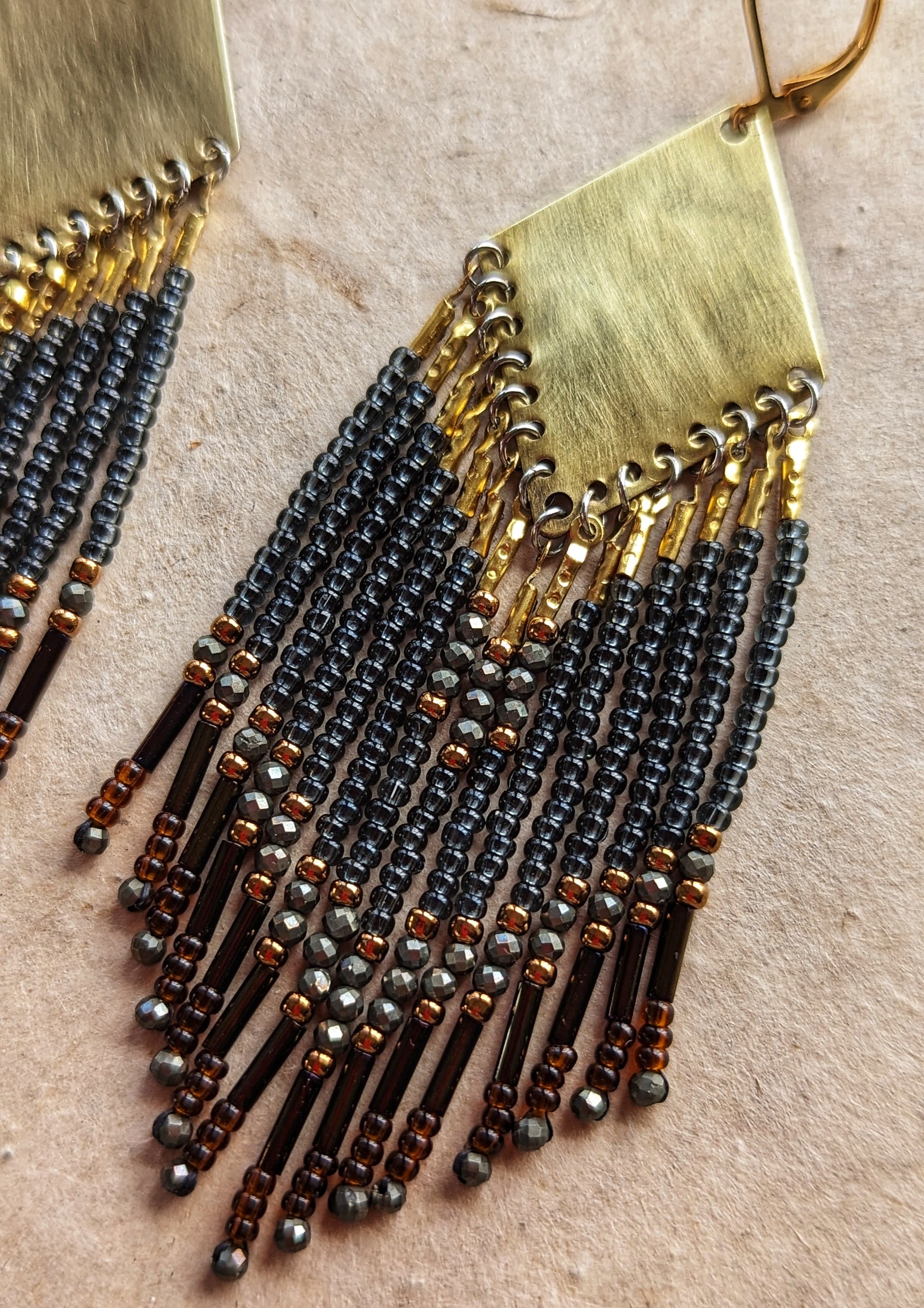 Moon & Milk handcrafted beaded earrings with black, bronze, and hematite accents, finished with brass findings and glass bugle bead fringe.