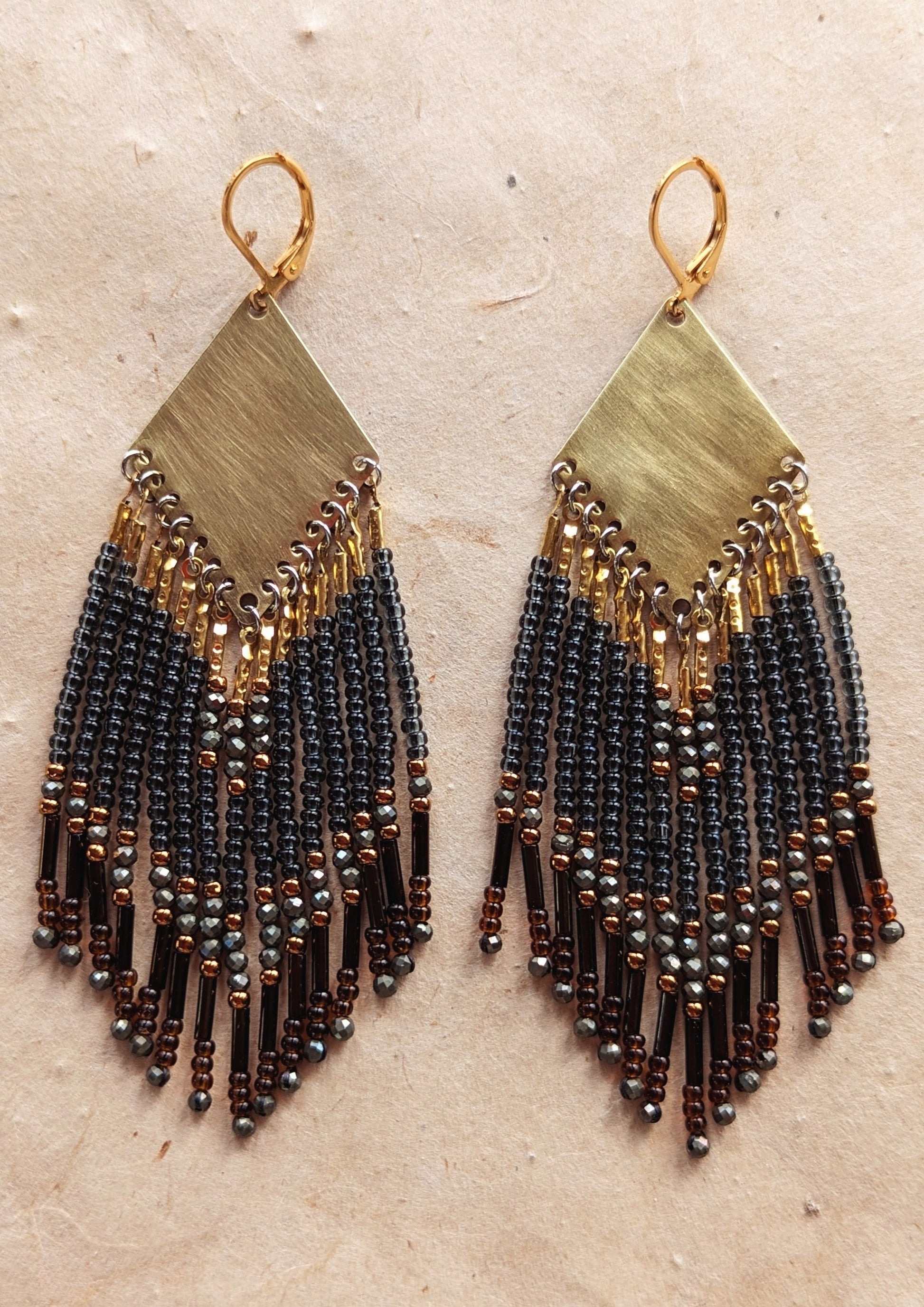 Moon & Milk handcrafted beaded earrings with black, bronze, and hematite accents, finished with brass findings and glass bugle bead fringe.
