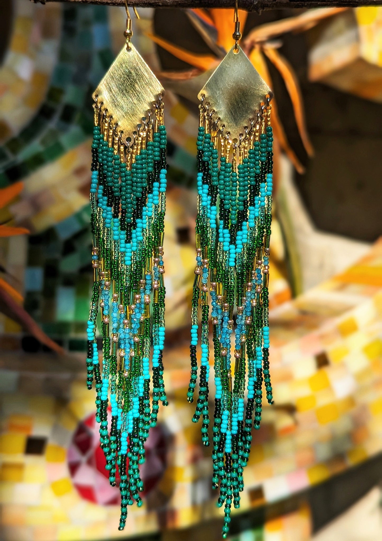 Long native earrings by Moon & Milk with turquoise, apatite, and green glass beads, featuring brass accents and intricate artisan beadwork.
