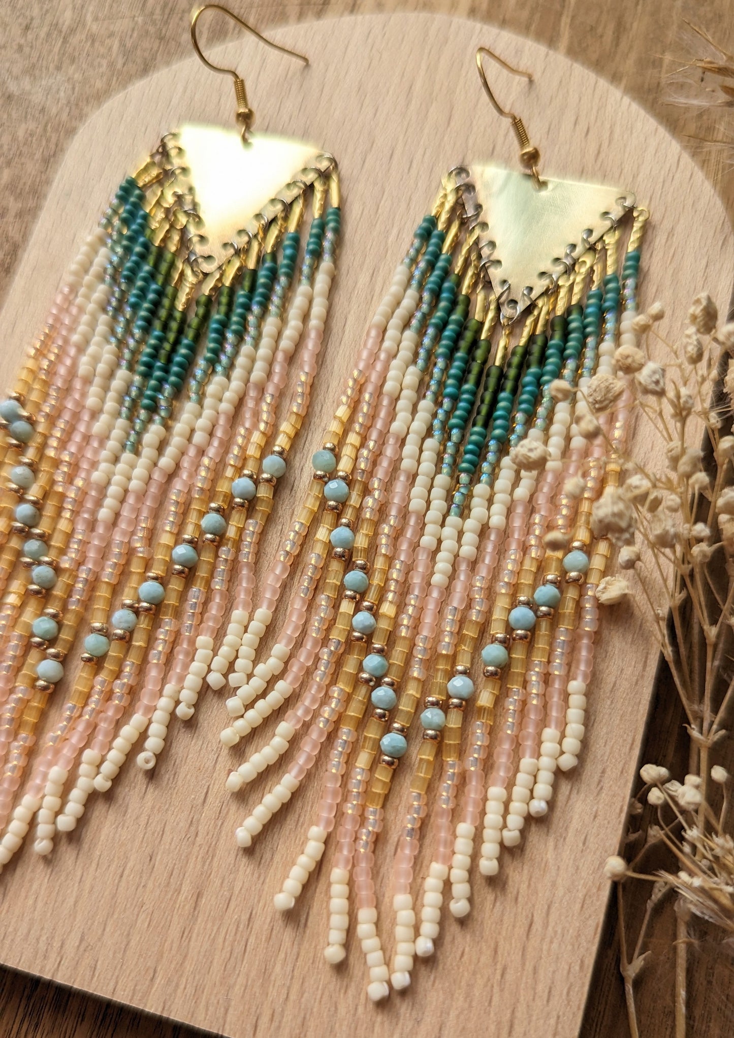 Long beaded earrings by Moon & Milk with soft pink, ivory, forest green, and sky blue larimar stones, finished with brass tops and handmade fringe design.