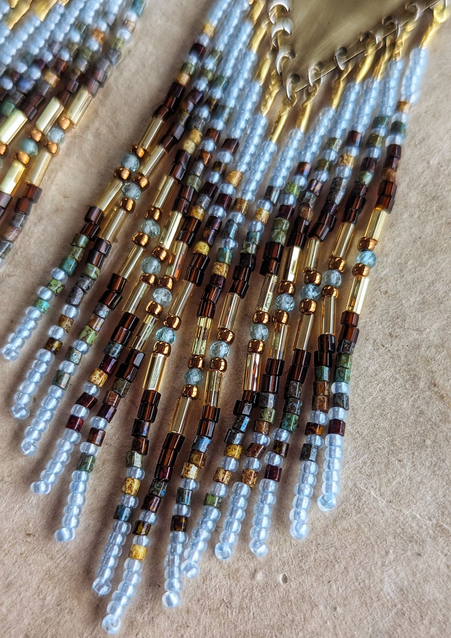 Moon & Milk beaded earrings blend earthy brown and watery blue seed beads with brass findings, handcrafted statement jewelry rooted in nature.