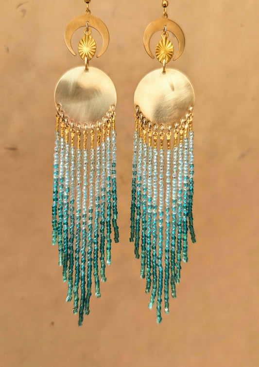Handcrafted aqua beaded earrings by Moon & Milk, featuring cascading glass beads in shades of blue and brass accents, reflecting the beauty of the sea.