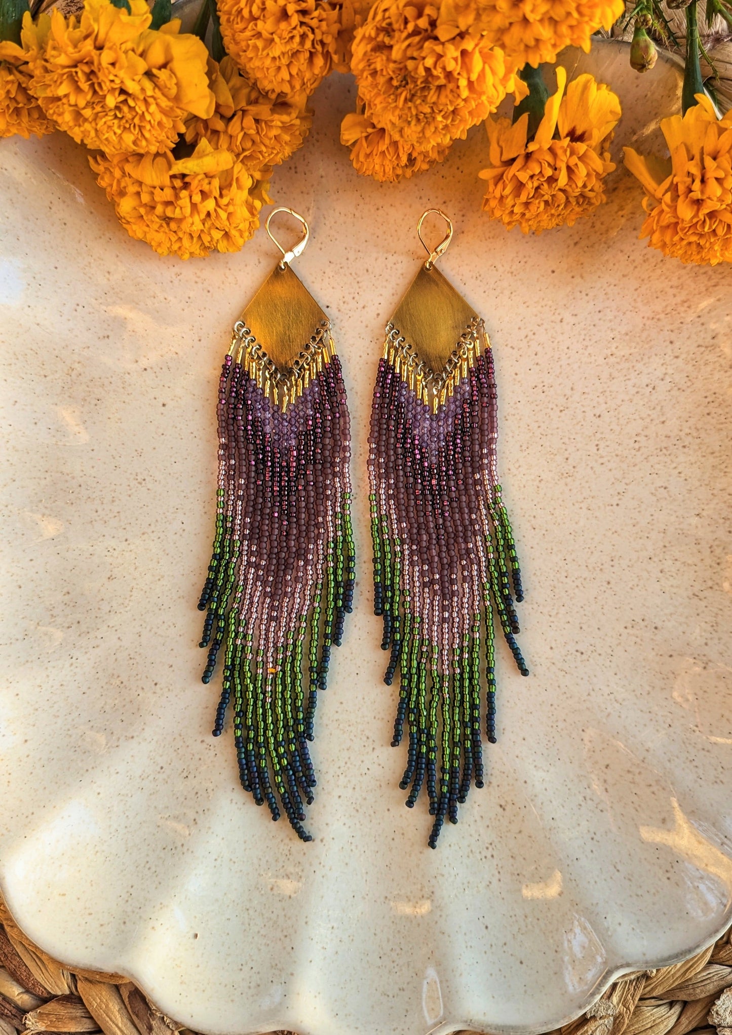 Moon & Milk handcrafted beaded earrings with purple, green, and navy glass beads, brass tops, and long fringe, designed as artisan wearable art.