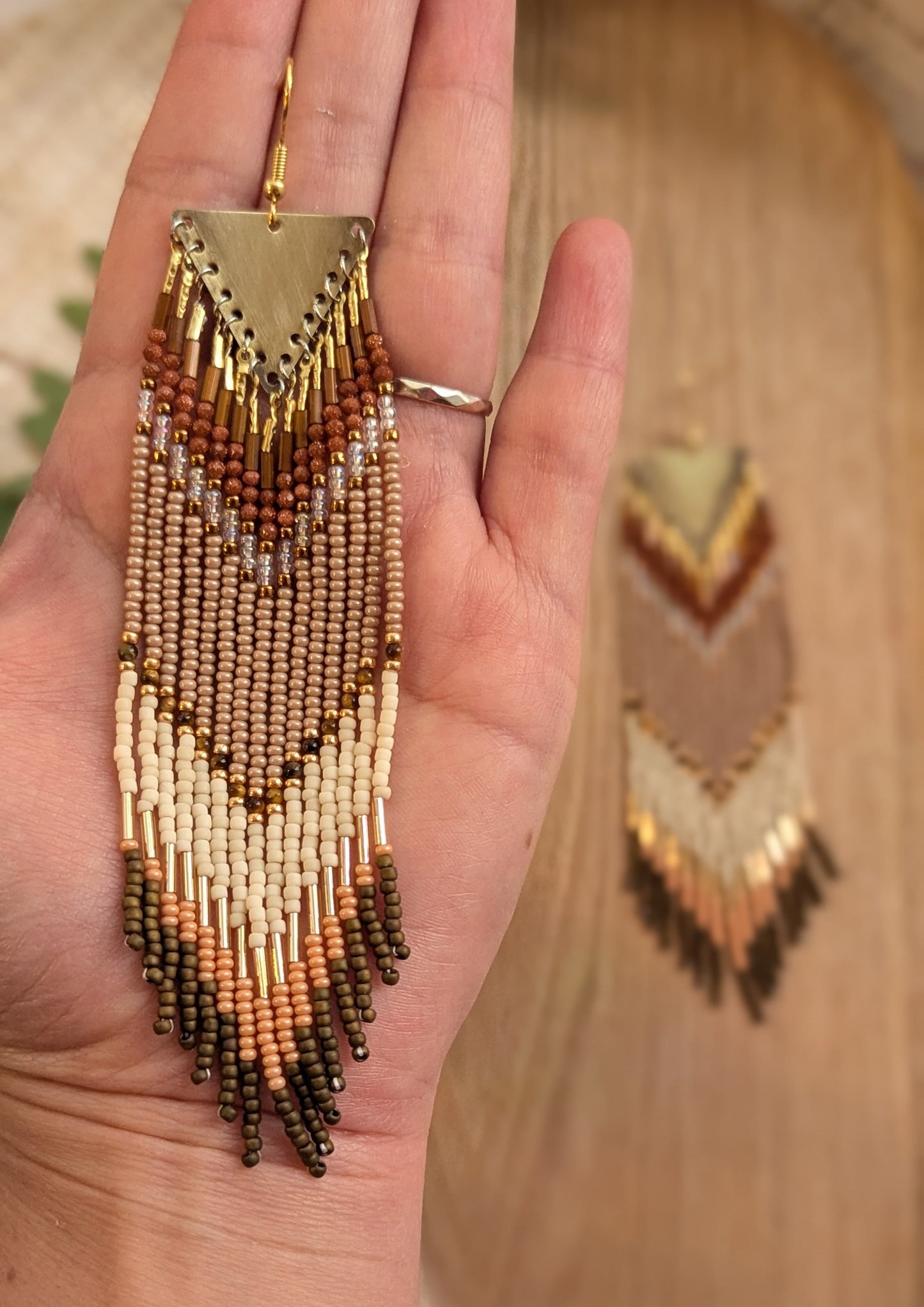 Long handcrafted fringe earrings by Moon & Milk with warm terracotta, beige, and ivory seed beads, finished with brass triangle tops and fine detailing.