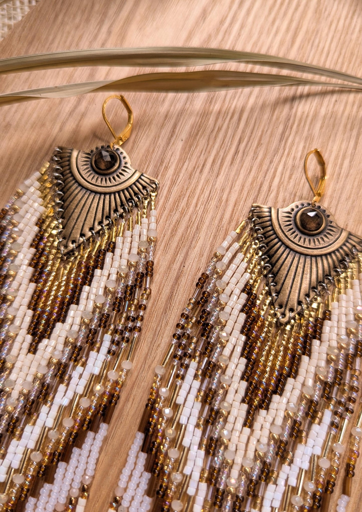 Beaded statement earrings by Moon & Milk with an all-seeing eye detail, handcrafted in earthy tones with bronze, ivory, and white seed beads.
