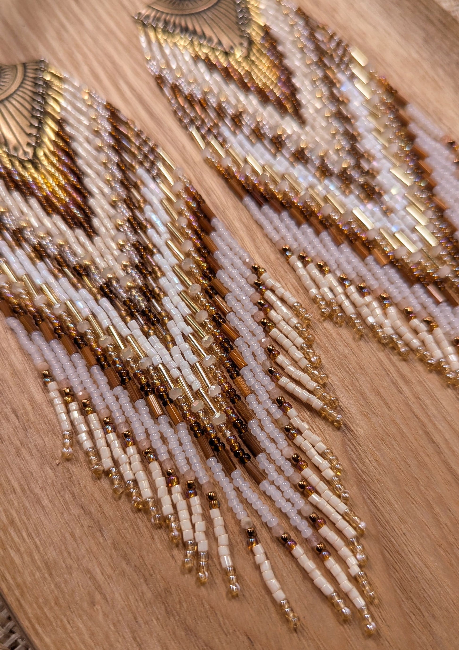Beaded statement earrings by Moon & Milk with an all-seeing eye detail, handcrafted in earthy tones with bronze, ivory, and white seed beads.