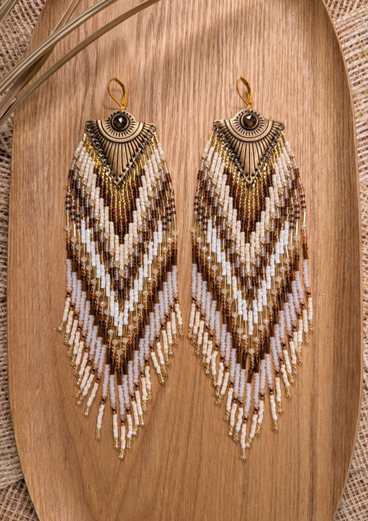 Beaded statement earrings by Moon & Milk with an all-seeing eye detail, handcrafted in earthy tones with bronze, ivory, and white seed beads.