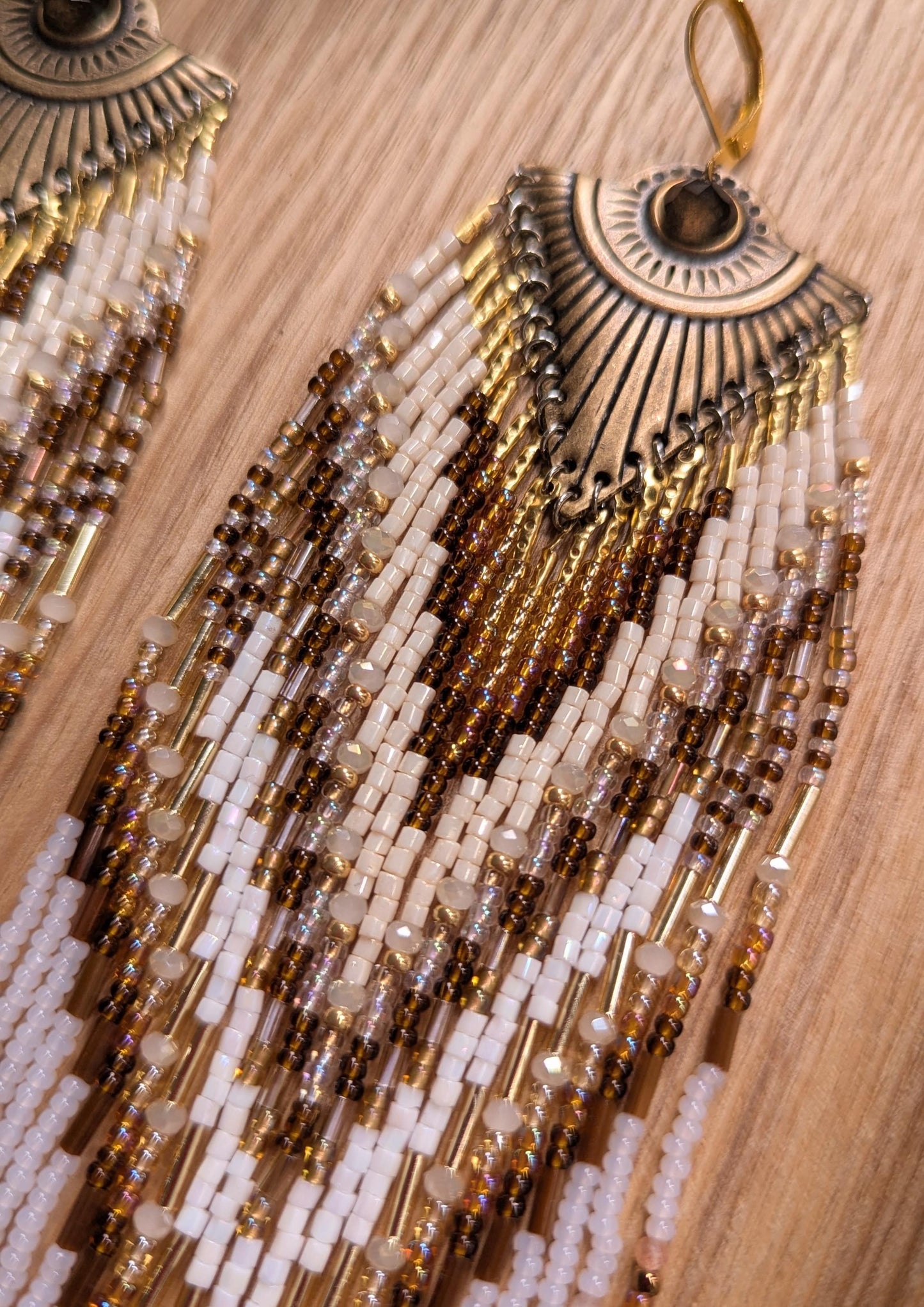Beaded statement earrings by Moon & Milk with an all-seeing eye detail, handcrafted in earthy tones with bronze, ivory, and white seed beads.
