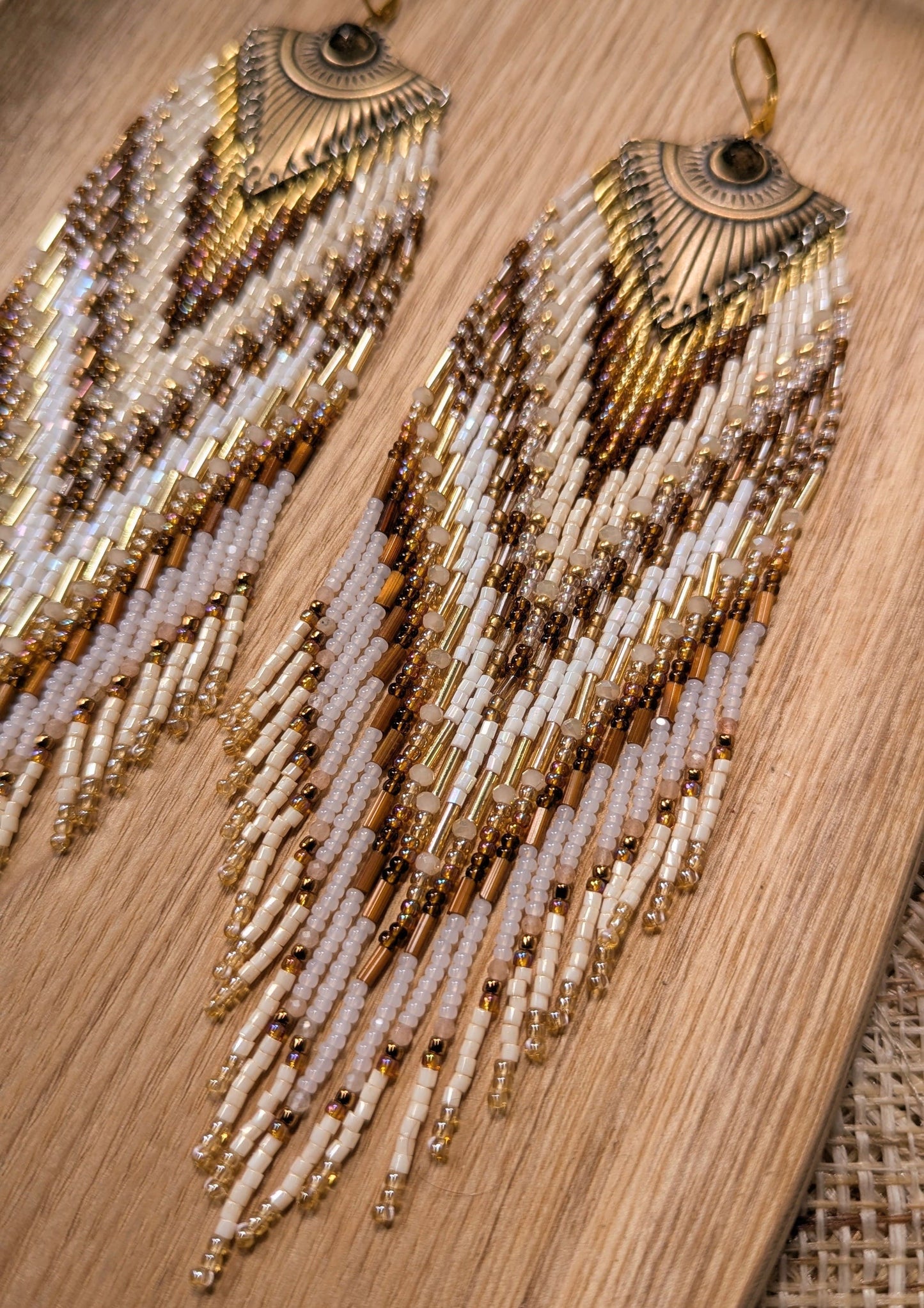 Beaded statement earrings by Moon & Milk with an all-seeing eye detail, handcrafted in earthy tones with bronze, ivory, and white seed beads.