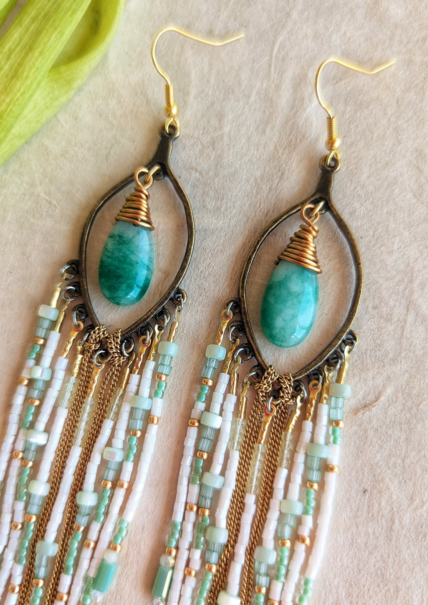 Moon & Milk mint green beaded earrings with long white, gold, and aqua fringe, featuring tear-shaped jade stones wrapped in gold brass wire.