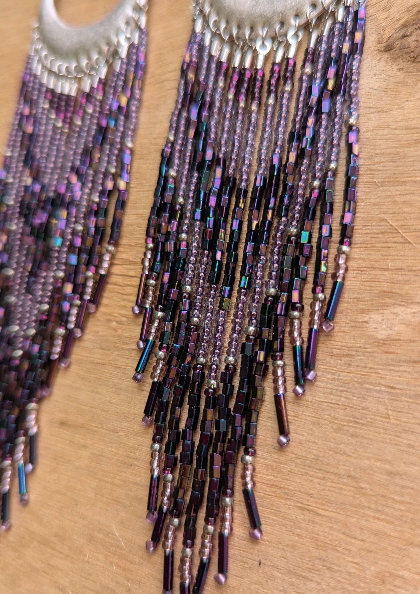 Moon & Milk crescent-shaped statement earrings with cascading purple, amethyst, and metallic seed beads and bugle beads on silver half-moon findings.