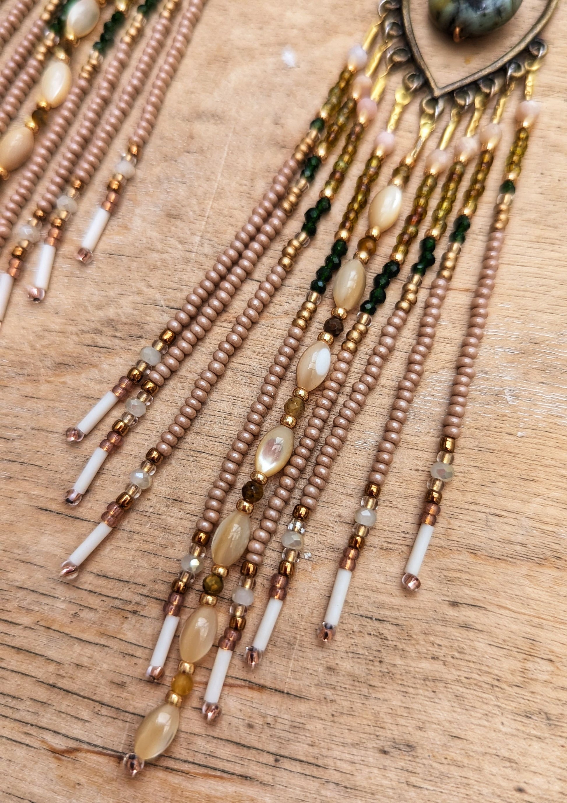 Hand-beaded earrings with various colors on a wooden surface.