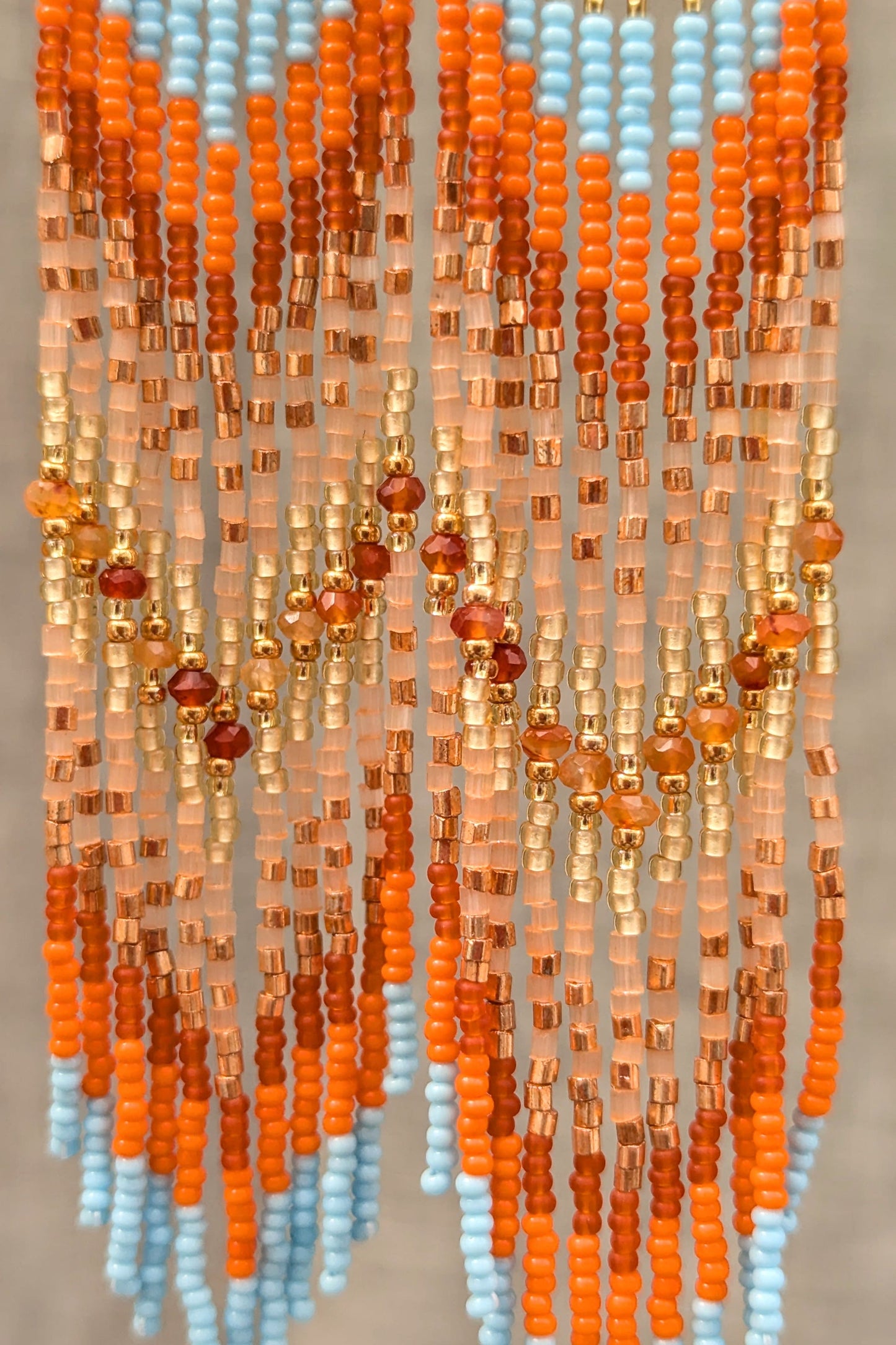 String of multicolored beads with a gradient effect on a neutral background.