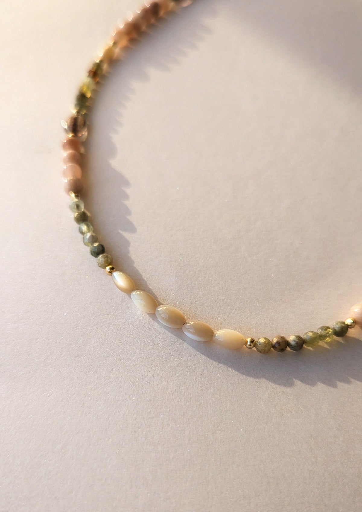 Mother of pearl beaded necklace on a light background.