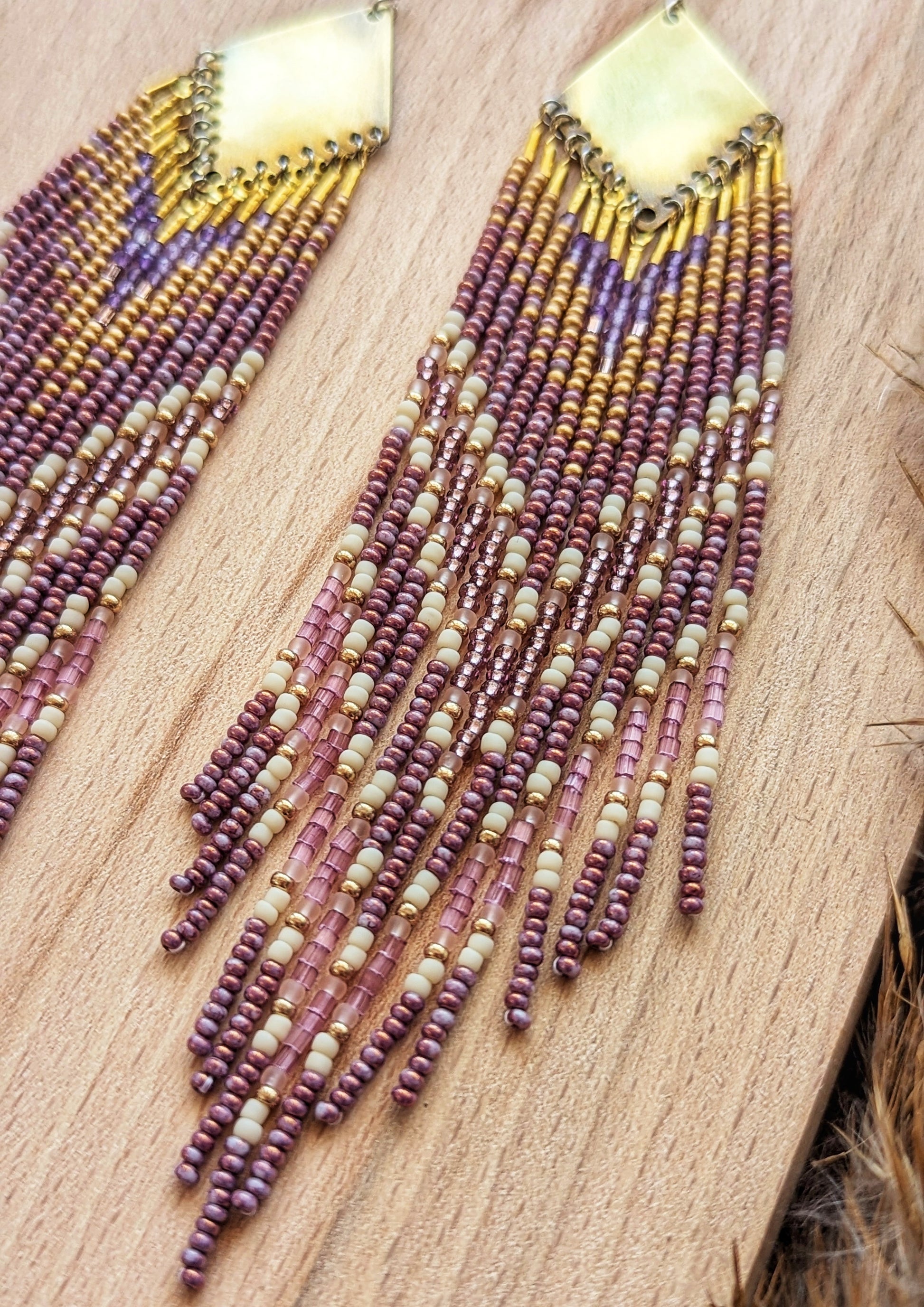 Moon & Milk long beaded earrings in gold, lavender, and cream tones, handcrafted with glass beads and brass for a soft, radiant native-inspired fringe design.