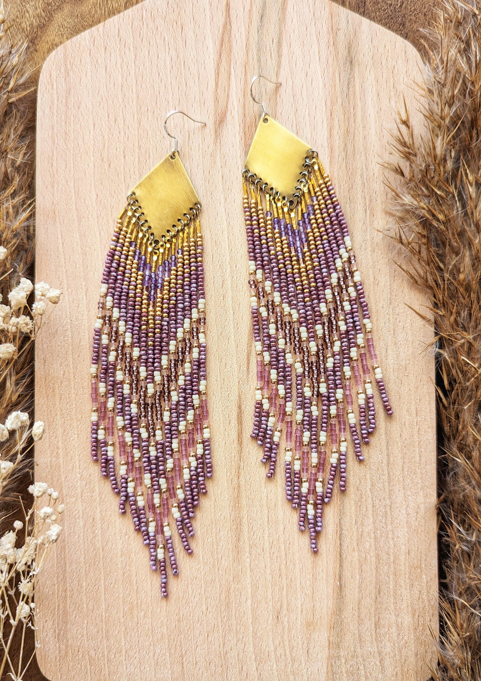 Moon & Milk long beaded earrings in gold, lavender, and cream tones, handcrafted with glass beads and brass for a soft, radiant native-inspired fringe design.