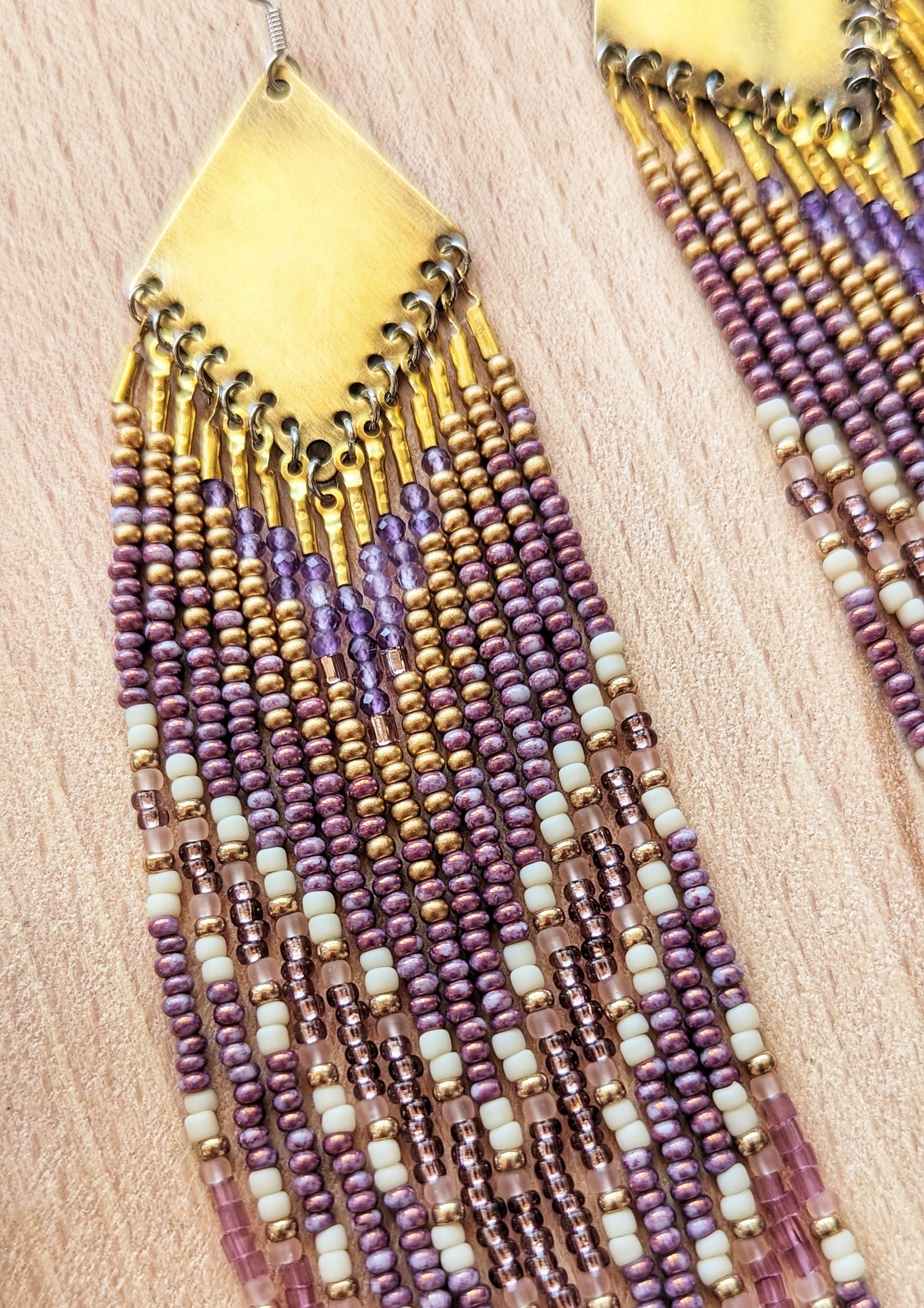 Moon & Milk long beaded earrings in gold, lavender, and cream tones, handcrafted with glass beads and brass for a soft, radiant native-inspired fringe design.