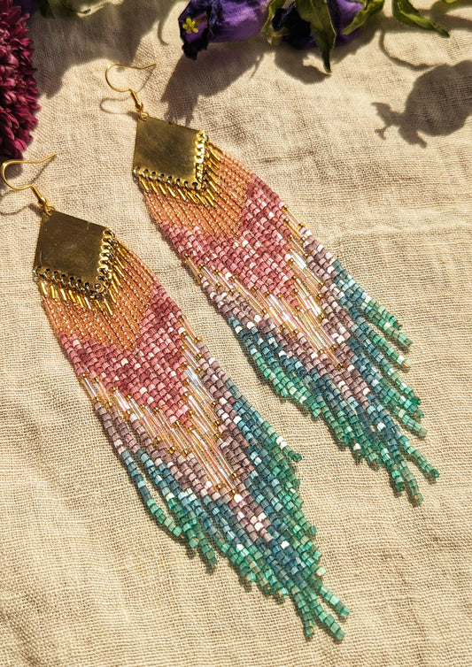 Moon & Milk handcrafted beaded earrings with a gradient of pink, purple, and teal beads, finished with gold-tone brass findings with an artisan design.