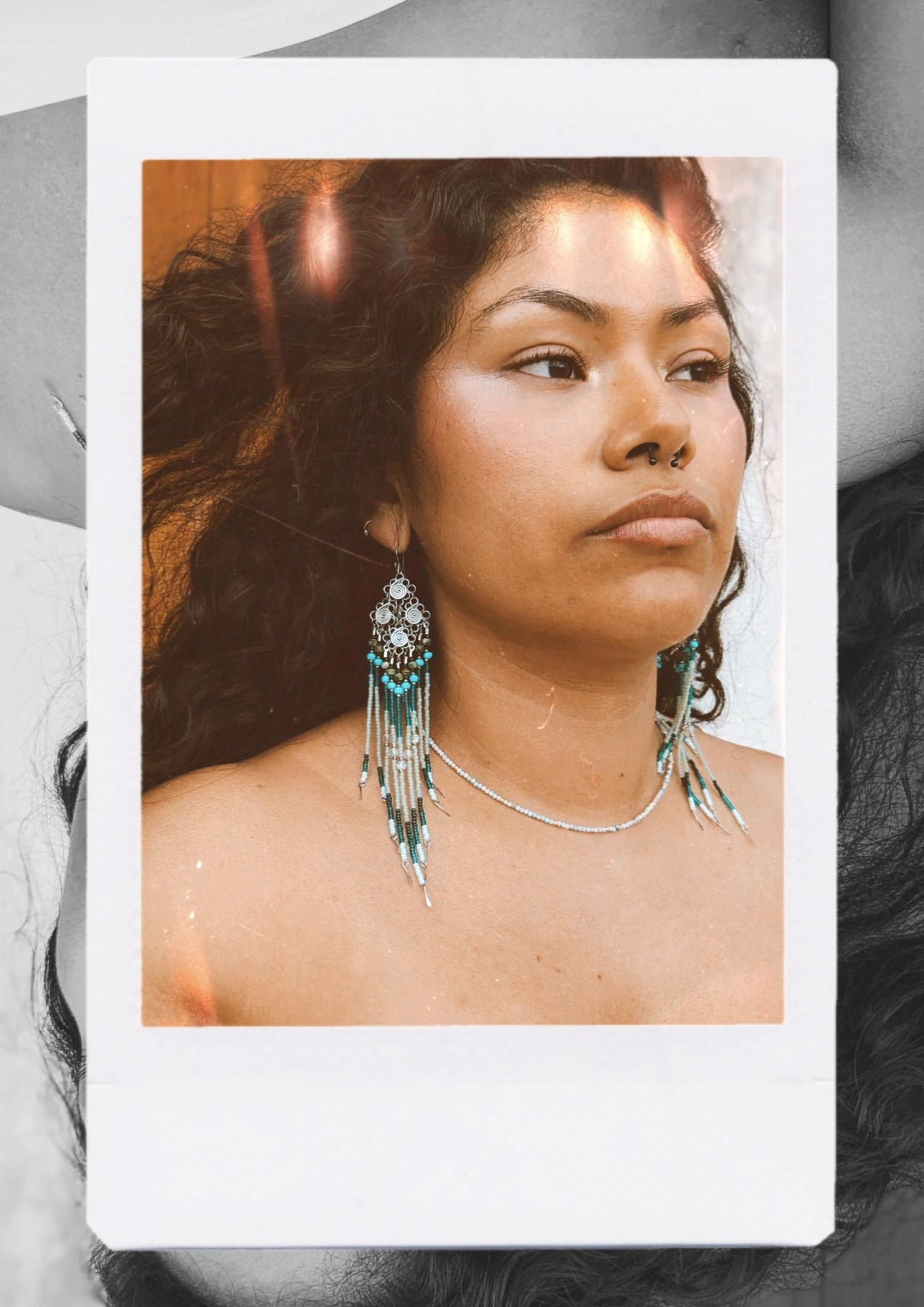 Polaroid-style photo of a person wearing long native earrings and a necklace with a blurred background.