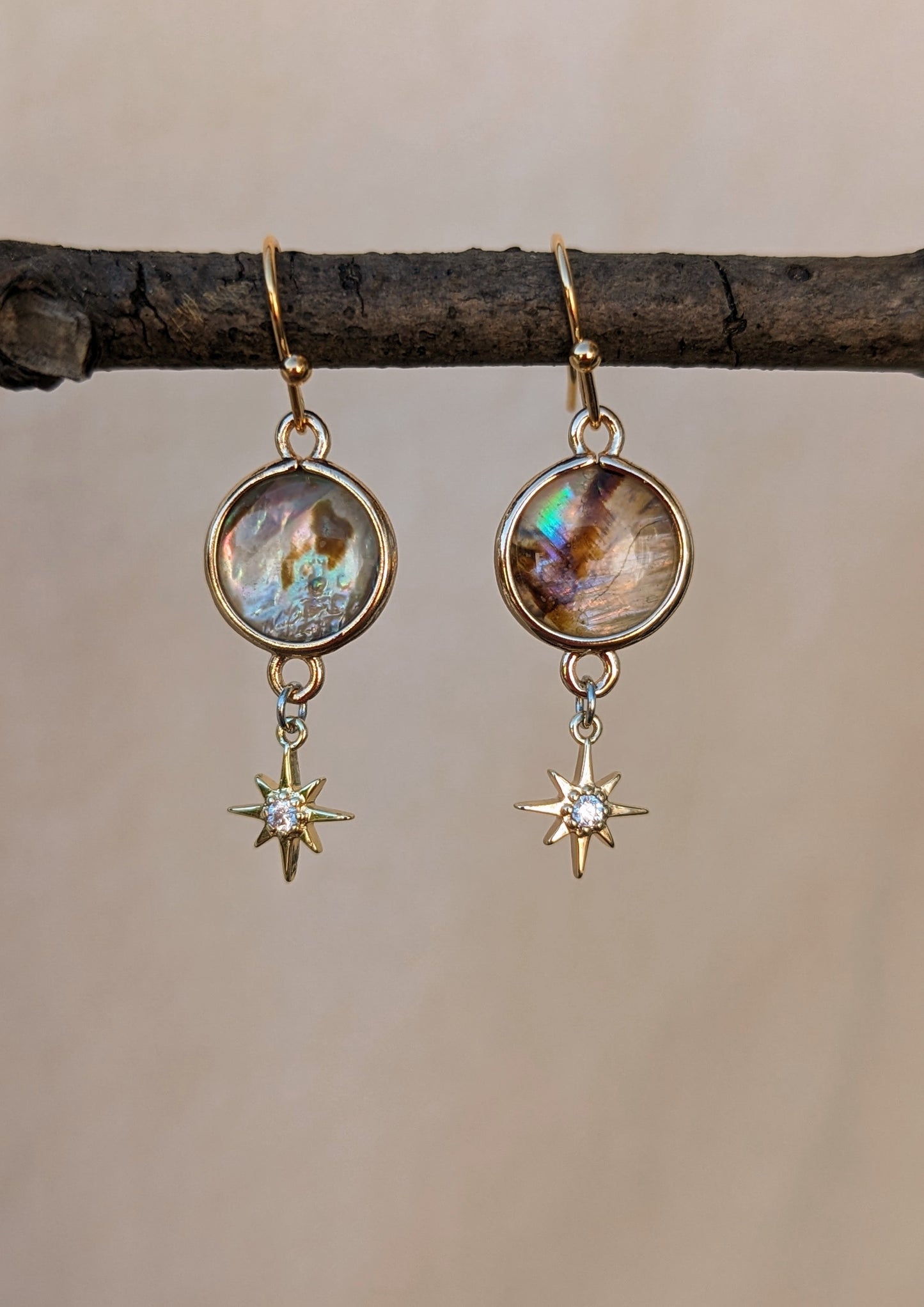 Andromeda earrings by Moon & Milk, featuring abalone shell connectors, CZ star charms, and 18k gold-plated brass ear wires, embodying a celestial-inspired design.