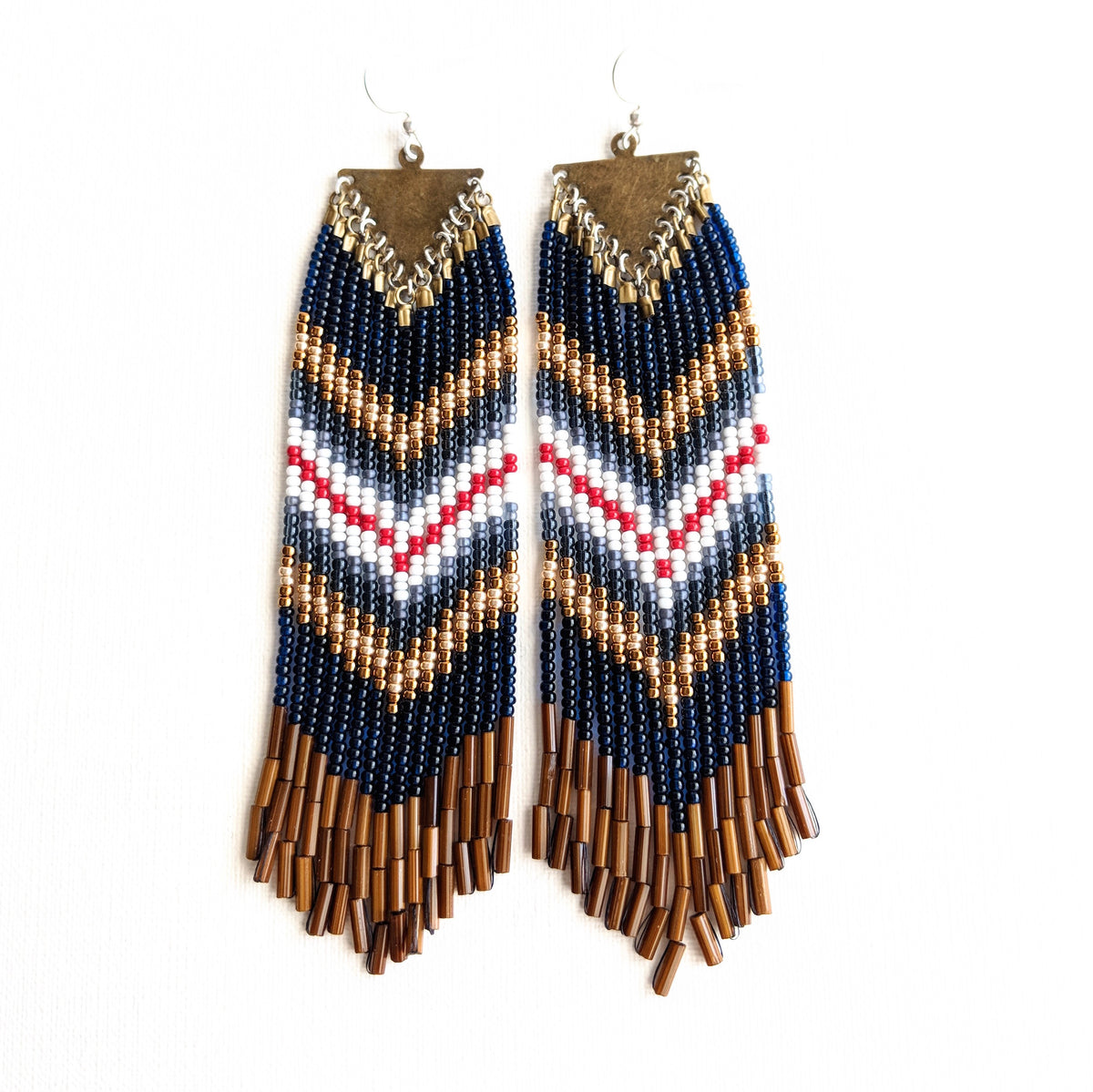 Moon & Milk handcrafted beaded earrings with navy, white, red, brass, and brown bugle beads in a chevron pattern on brass triangle findings, photographed on white.