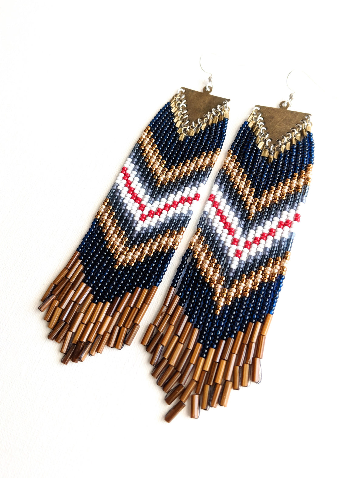 Moon & Milk handcrafted beaded earrings with navy, white, red, brass, and brown bugle beads in a chevron pattern on brass triangle findings, photographed on white.