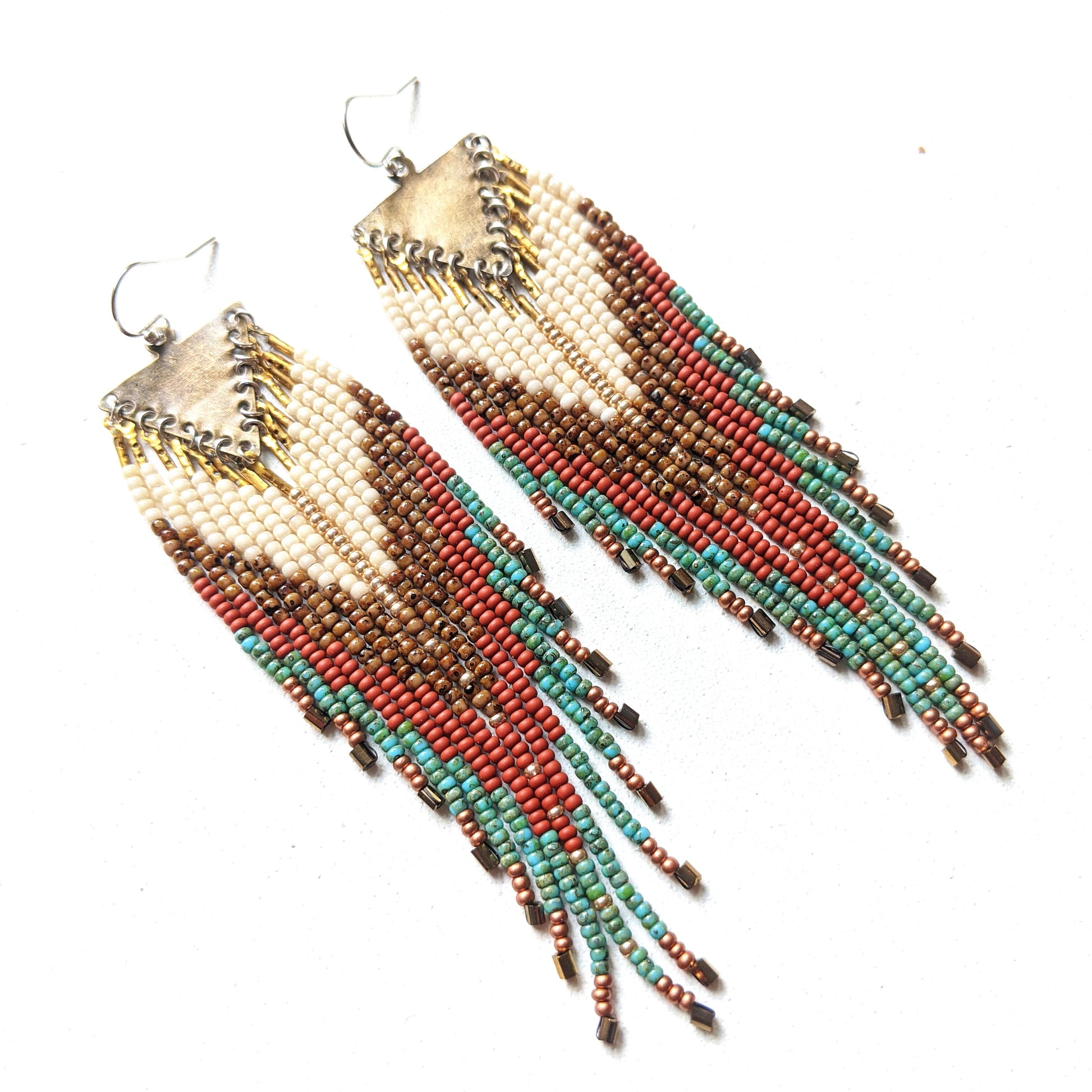 Moon & Milk - Handmade beaded earrings featuring a mix of ivory, brown, terracotta, and turquoise beads with a vintage brass chevron pendant, perfect for boho-chic and Southwestern-inspired fashion.