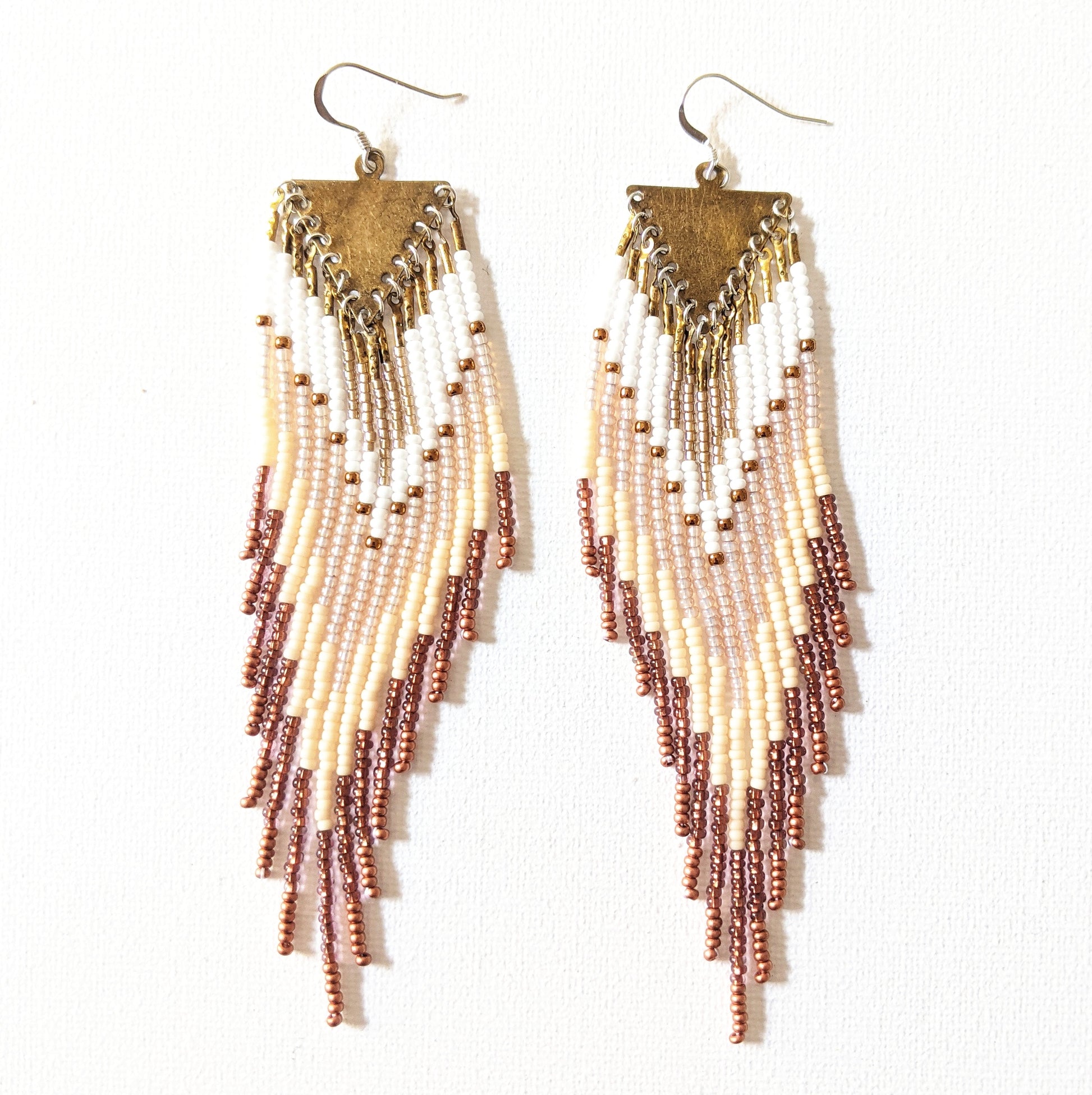 Handmade beaded fringe earrings by Moon & Milk with ivory, bronze, and white seed beads, suspended from brass triangle tops in a cascading pattern.