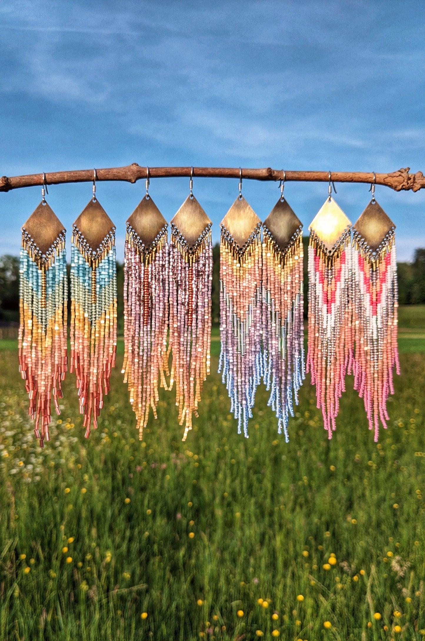 Handcrafted beaded earrings by Moon & Milk featuring vibrant Czech beads in gradient colors, with brass diamond-shaped accents, showcasing unique beadwork and design.