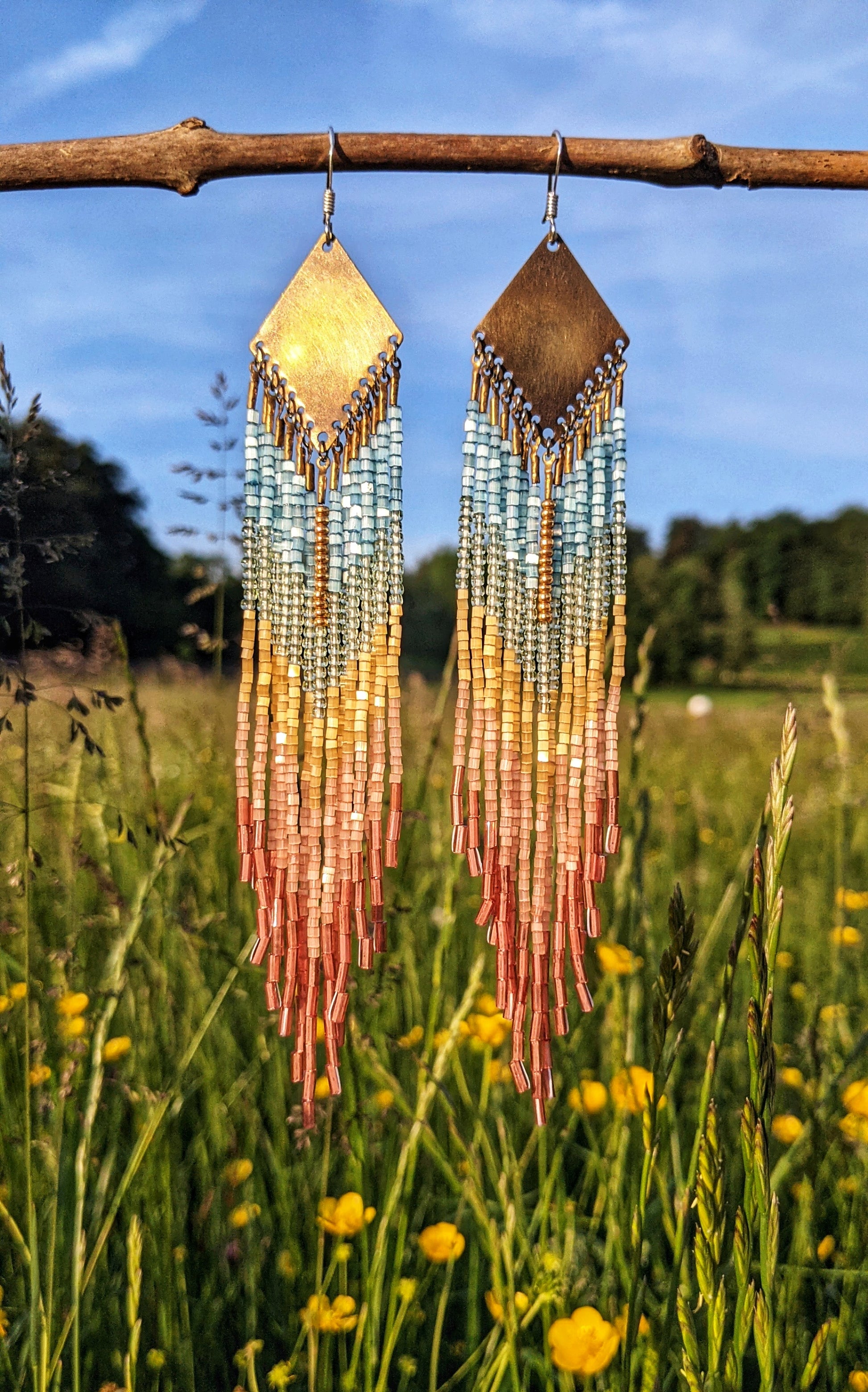 Moon & Milk beaded earrings featuring Czech hex-cut beads in blue, yellow, and coral, with brass tops.