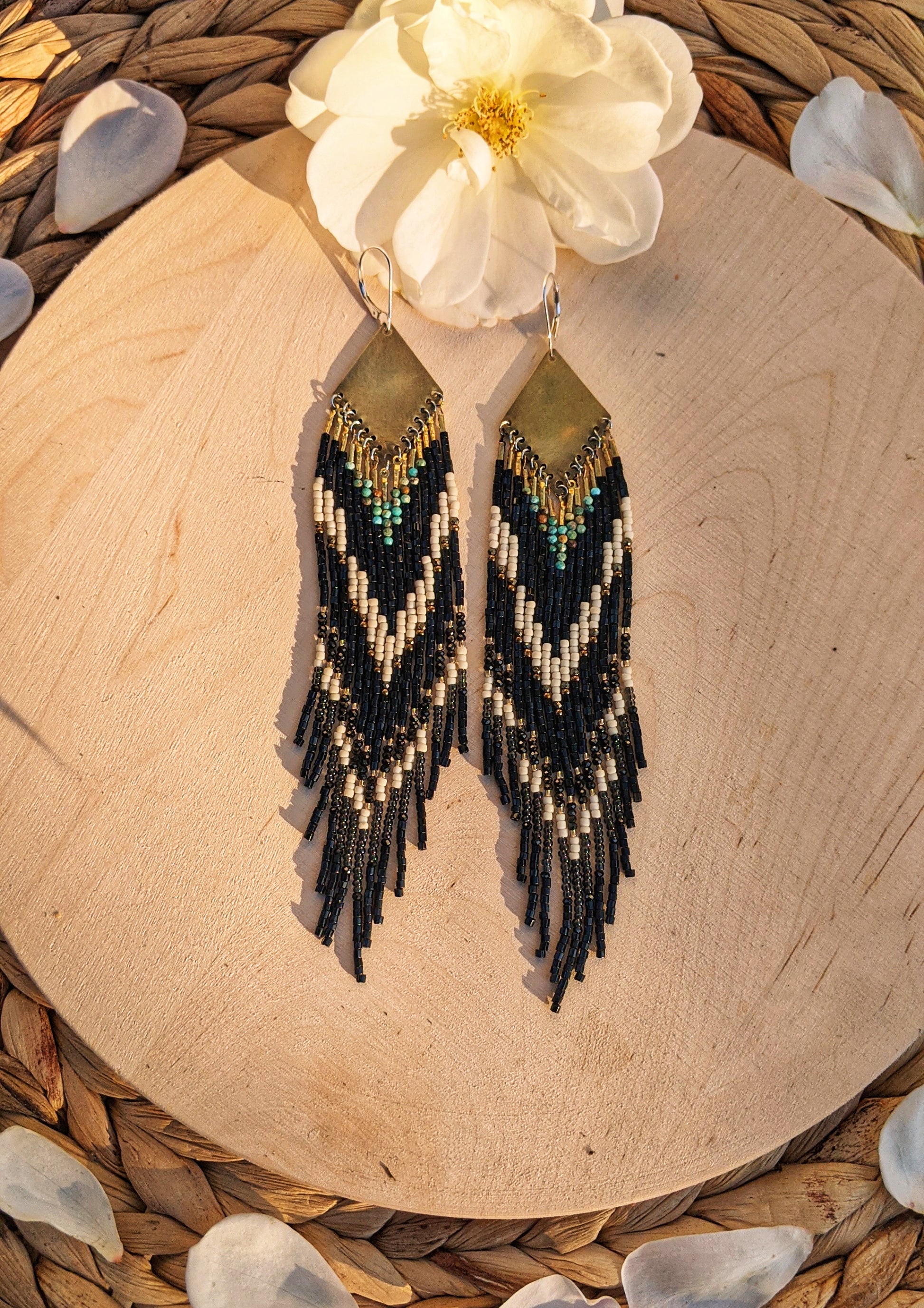 Long native beaded earrings in black, cream, and turquoise stones with brass tops, handcrafted for lovers of artisan jewelry and wearable art by Moon & Milk.