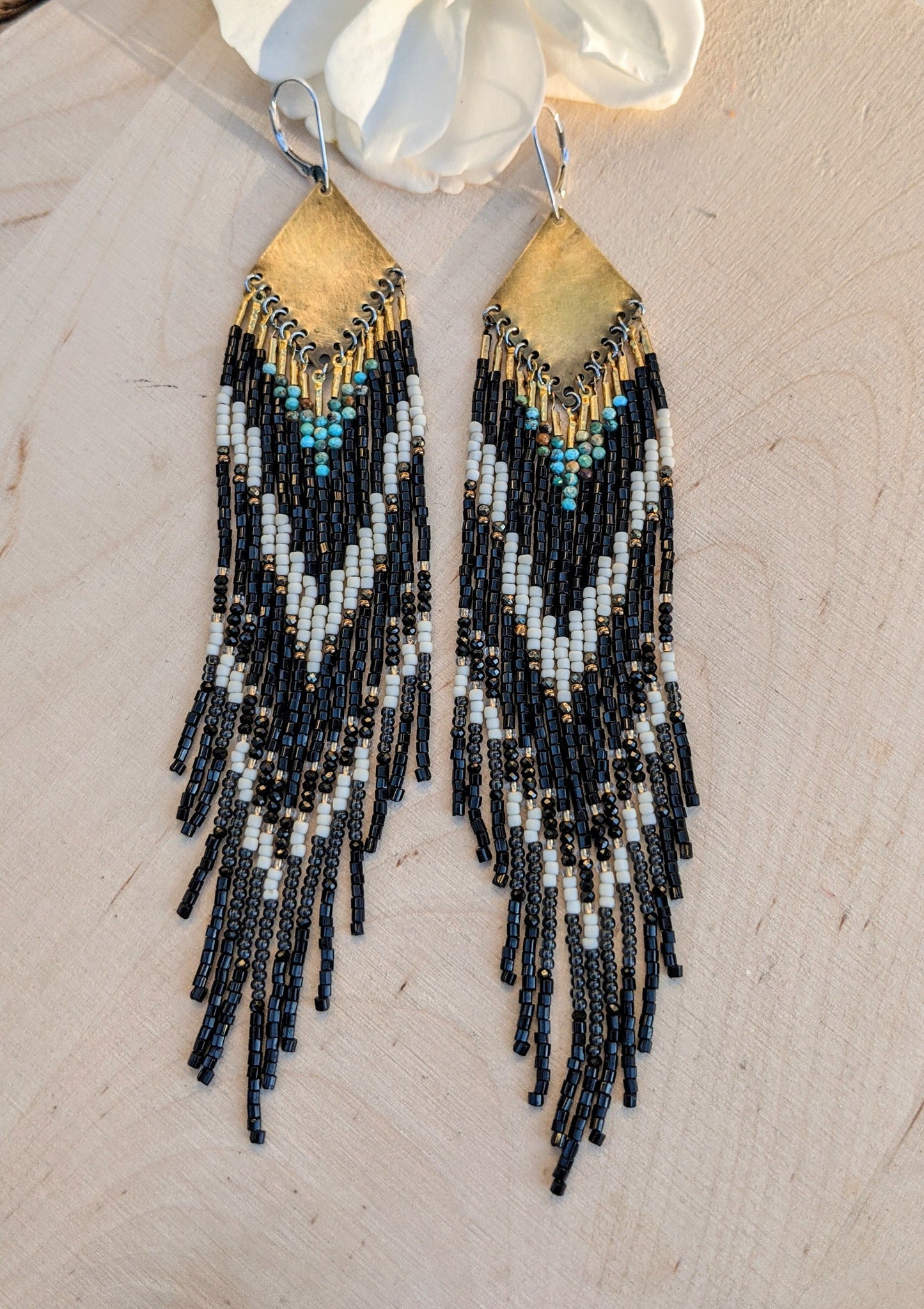 Long native beaded earrings in black, cream, and turquoise stones with brass tops, handcrafted for lovers of artisan jewelry and wearable art by Moon & Milk.