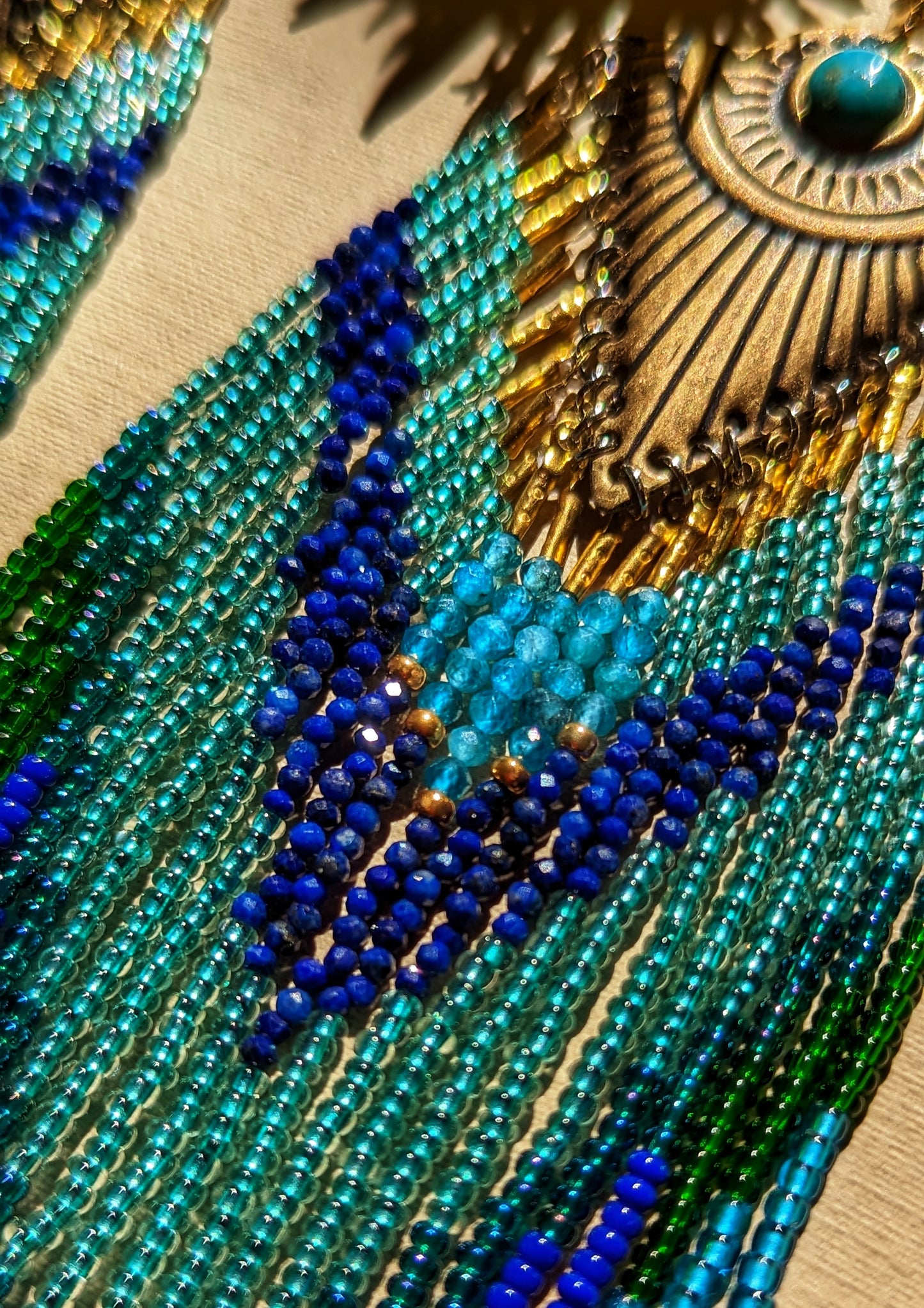 Handcrafted beaded earrings by Moon & Milk inspired by Huitzilopochtli, featuring apatite, lapis lazuli stones, and turquoise cabochons, designed to mimic a hummingbird.
