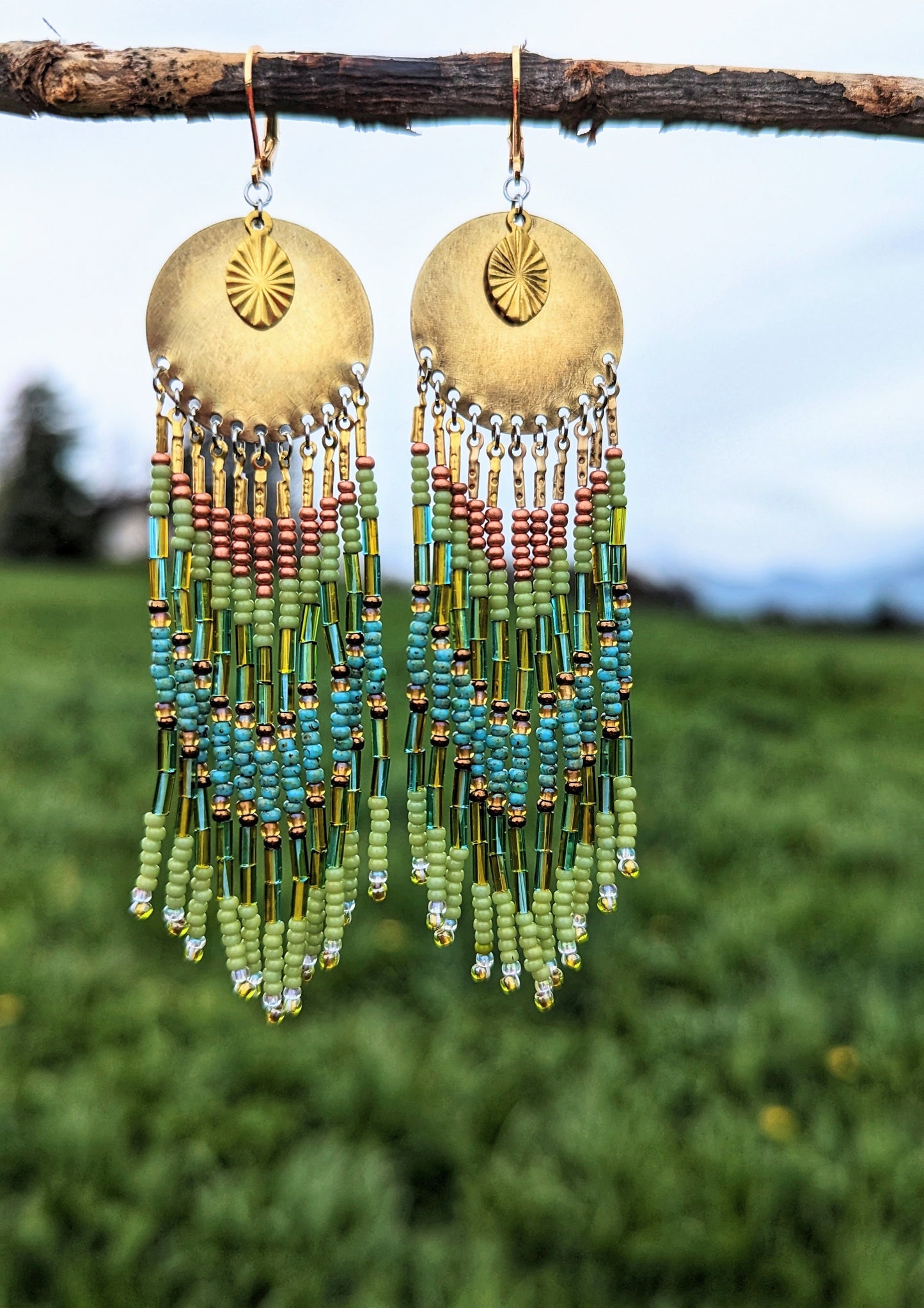 Moon & Milk handcrafted earrings with brass medallion, lime green, copper, and turquoise beaded fringe, inspired by the colors of the rainforest.