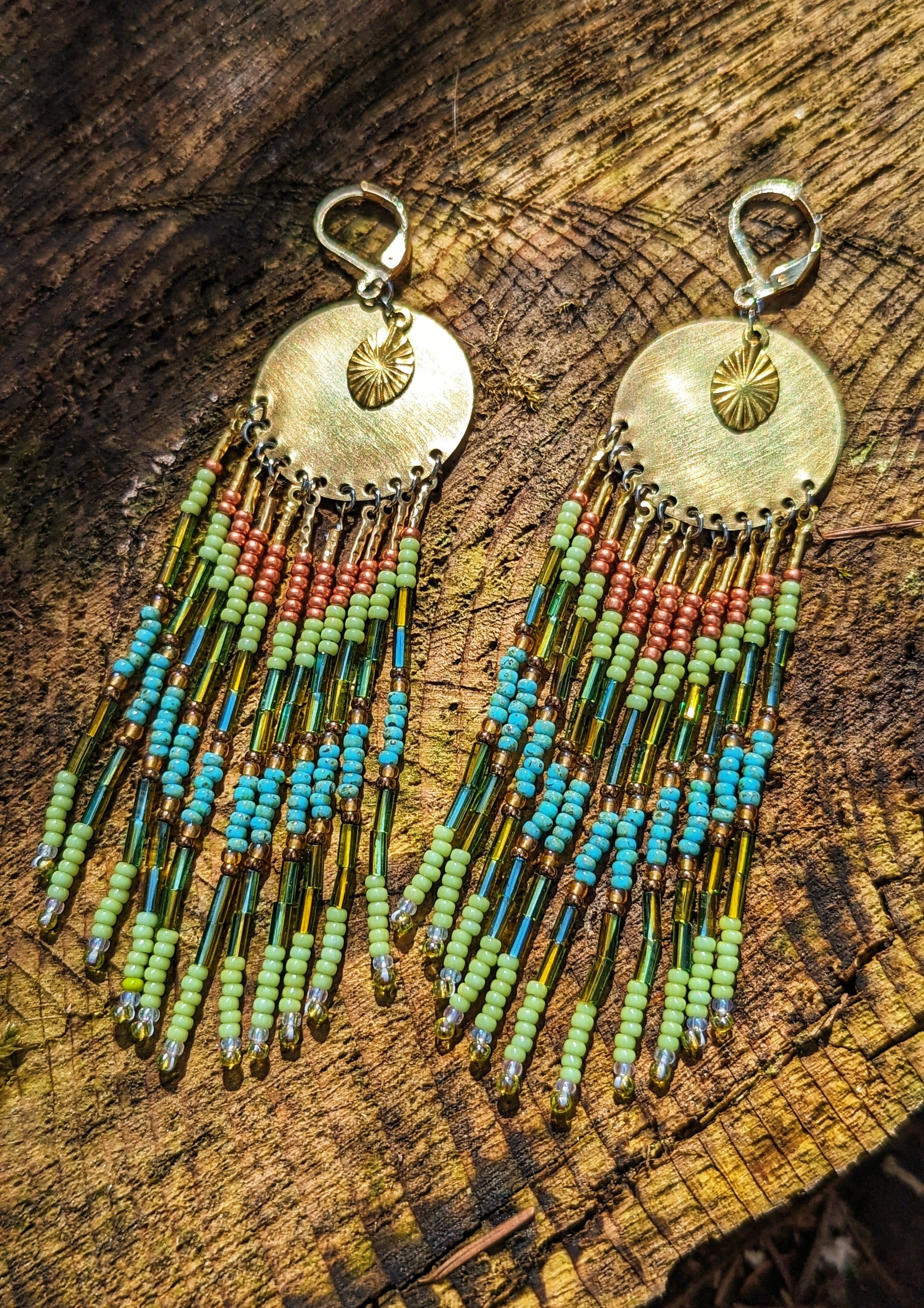 Moon & Milk handcrafted earrings with brass medallion, lime green, copper, and turquoise beaded fringe, inspired by the colors of the rainforest.