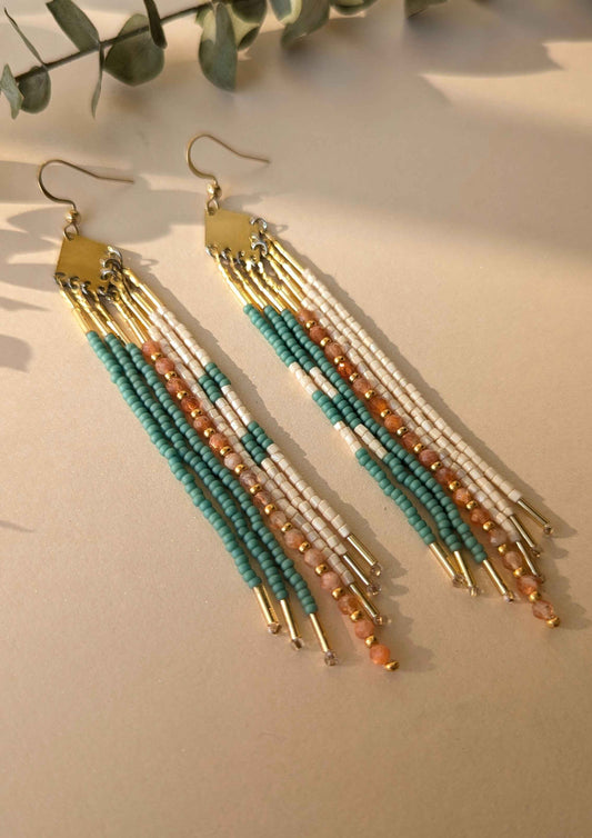 Beaded earrings with gold, turquoise, and sunstone beads on a light background.