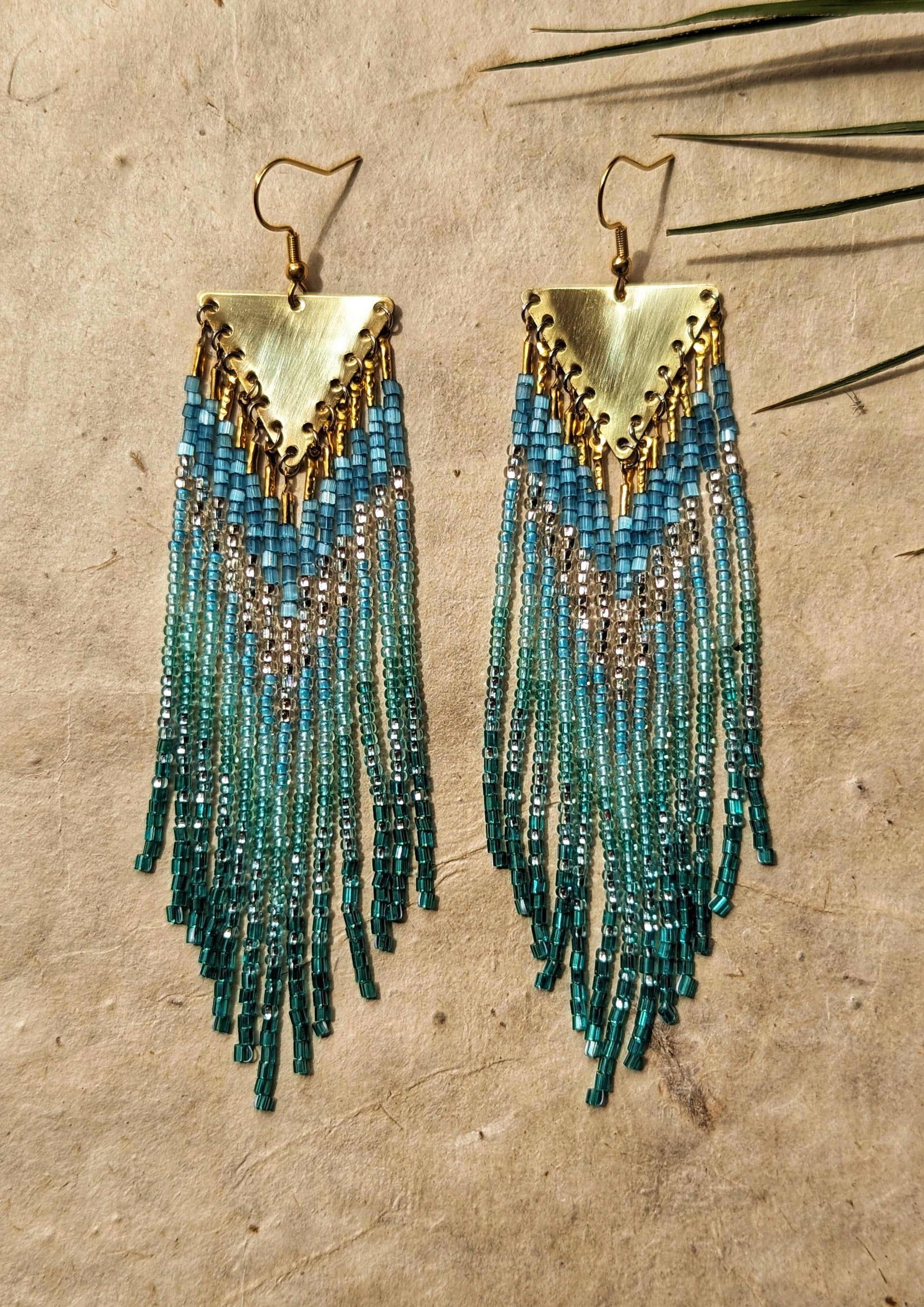 Moon & Milk - Handmade boho beaded earrings with blue and green cascading strands, accented with gold triangular pendants.