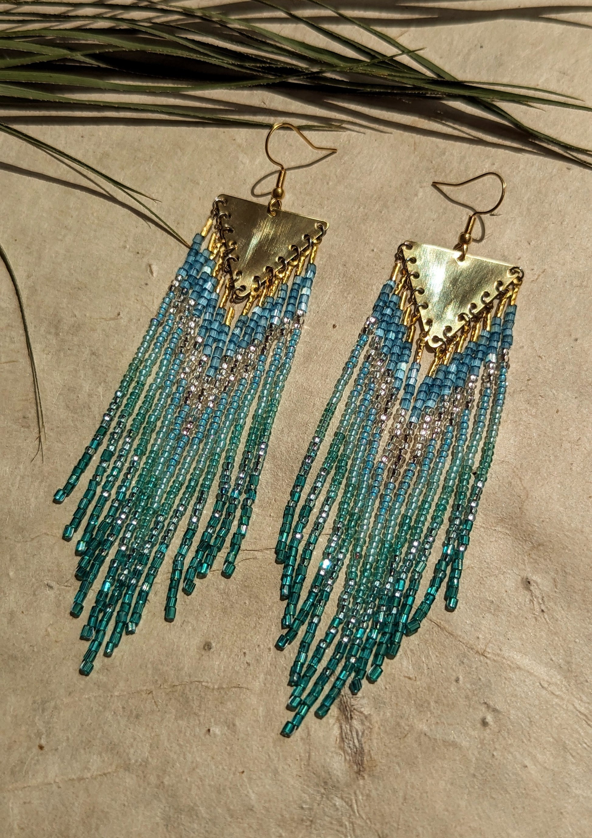 Moon & Milk - Handmade boho beaded earrings with blue and green cascading strands, accented with gold triangular pendants.