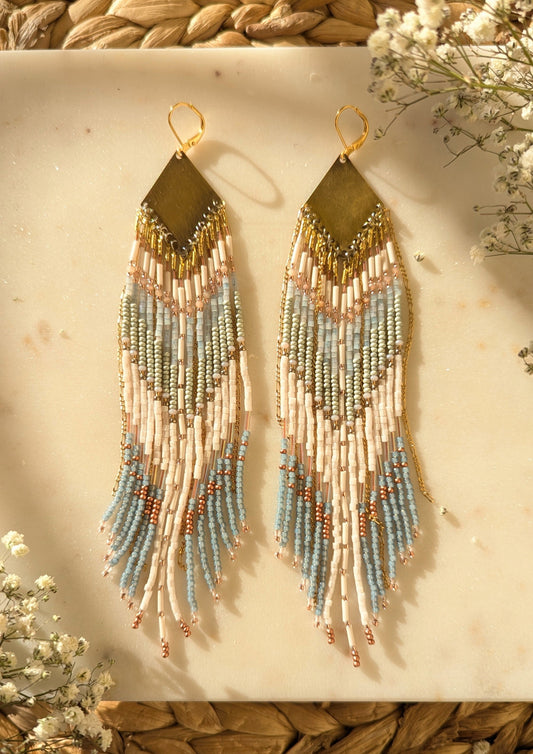 Handcrafted beaded fringe earrings featuring a chevron pattern in pastel blue, ivory, and gold, with cascading beaded fringes for a bohemian-inspired look.