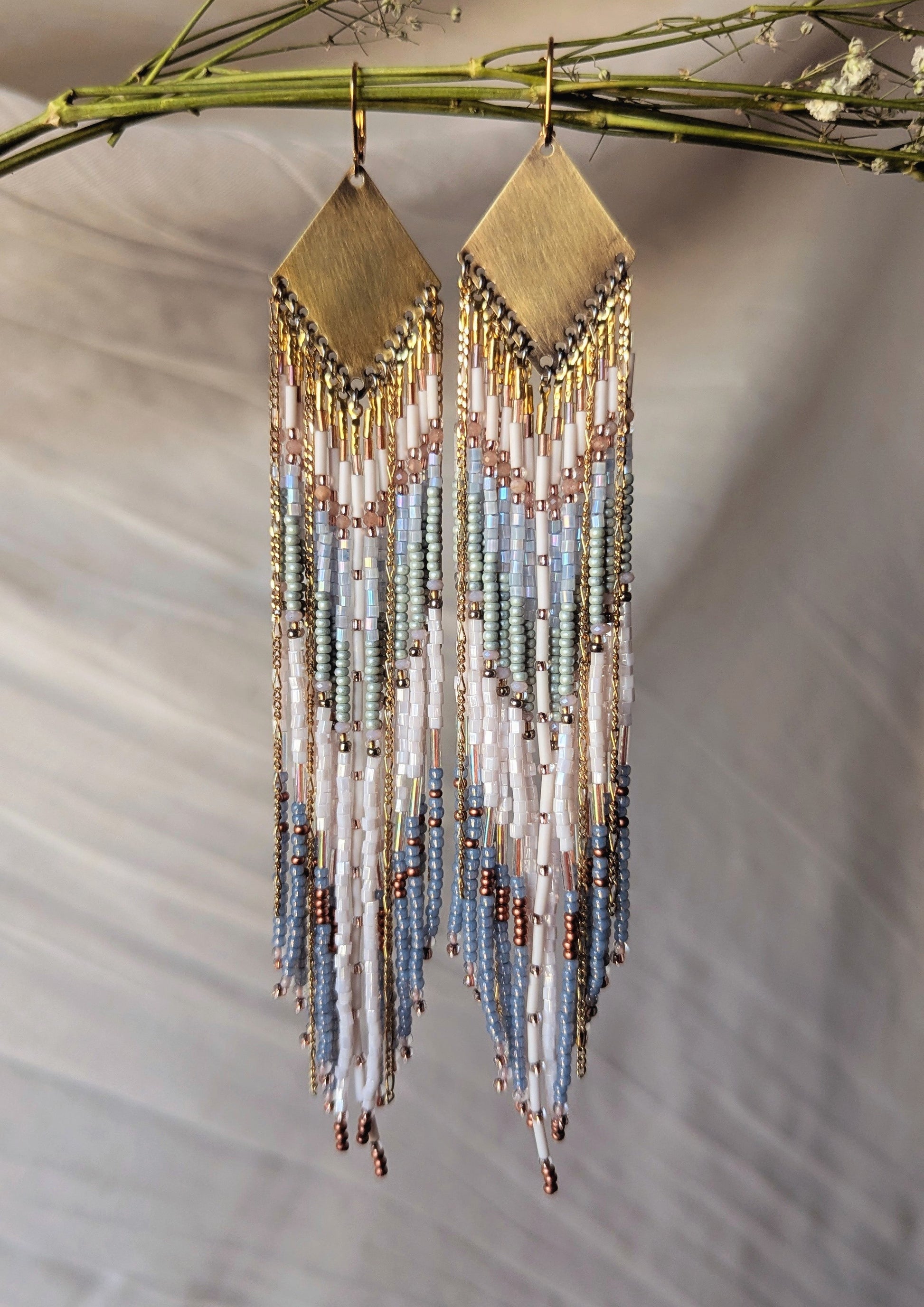 Handcrafted beaded fringe earrings featuring a chevron pattern in pastel blue, ivory, and gold, with cascading beaded fringes for a bohemian-inspired look.