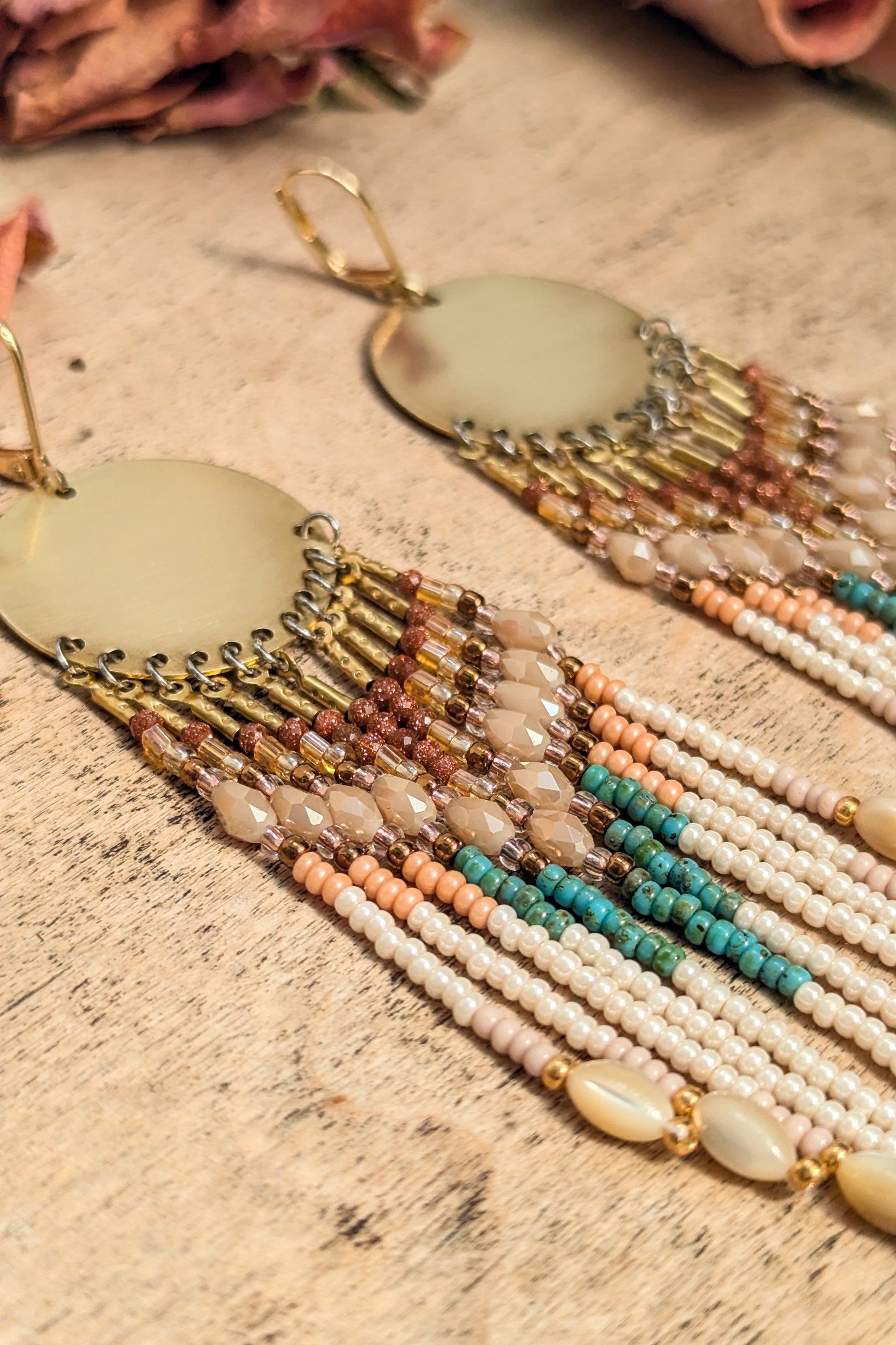 Beaded earrings with multiple color strands on a textured surface by Moon & Milk.