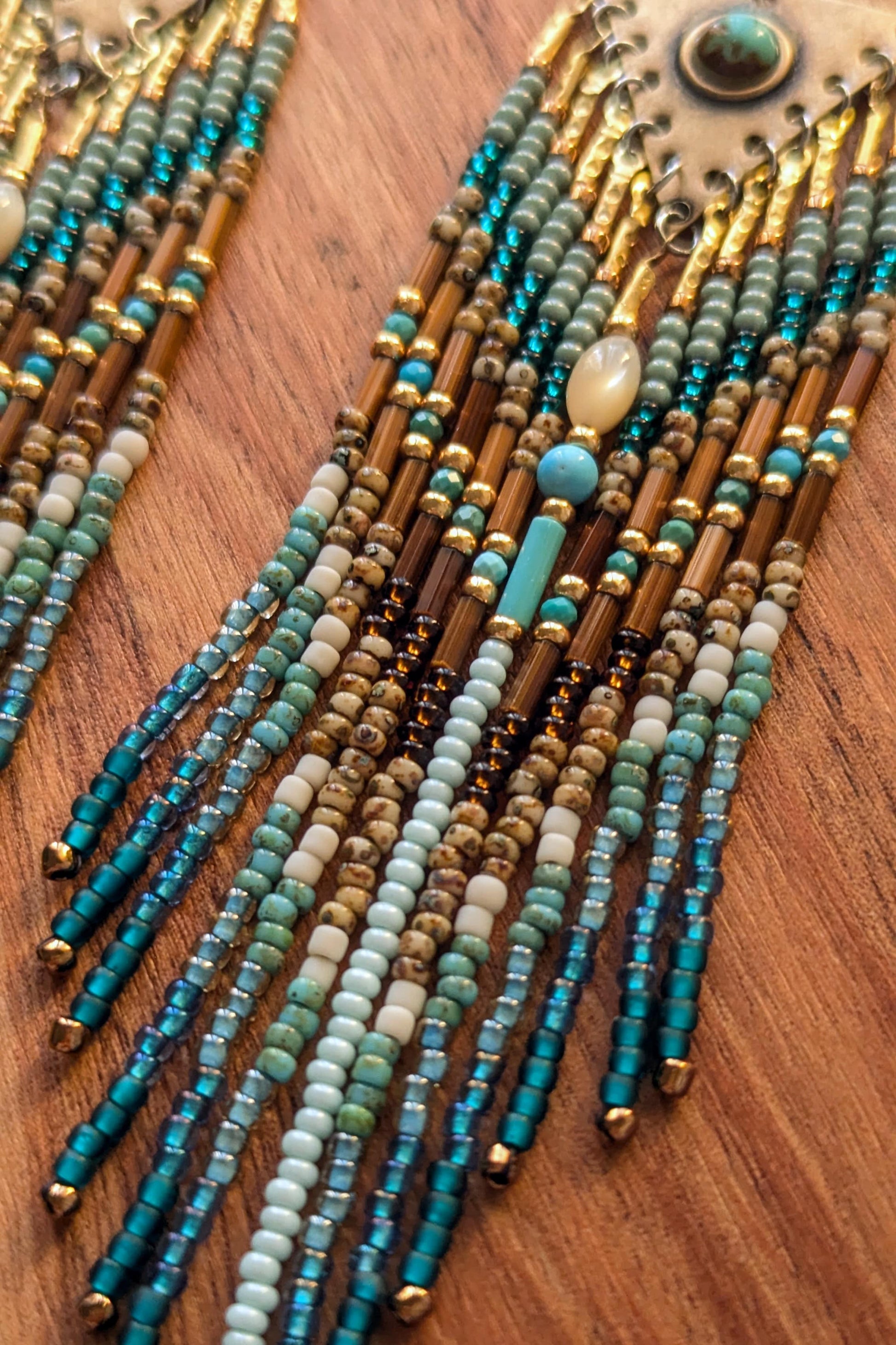 Close-up of beaded earrings in various colors on a wooden surface