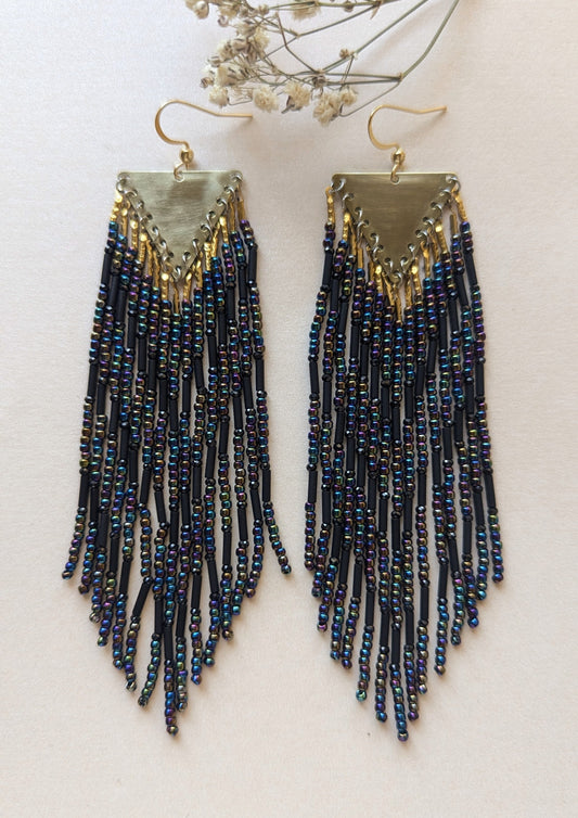 Pair of black beaded fringe earrings on a light background.