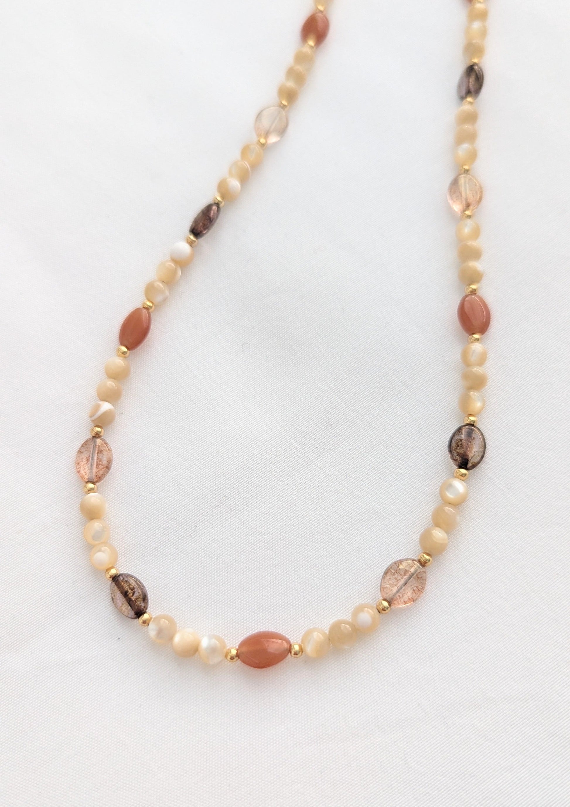 Necklace with mother-of-pearl and Czech glass beads on a white background.