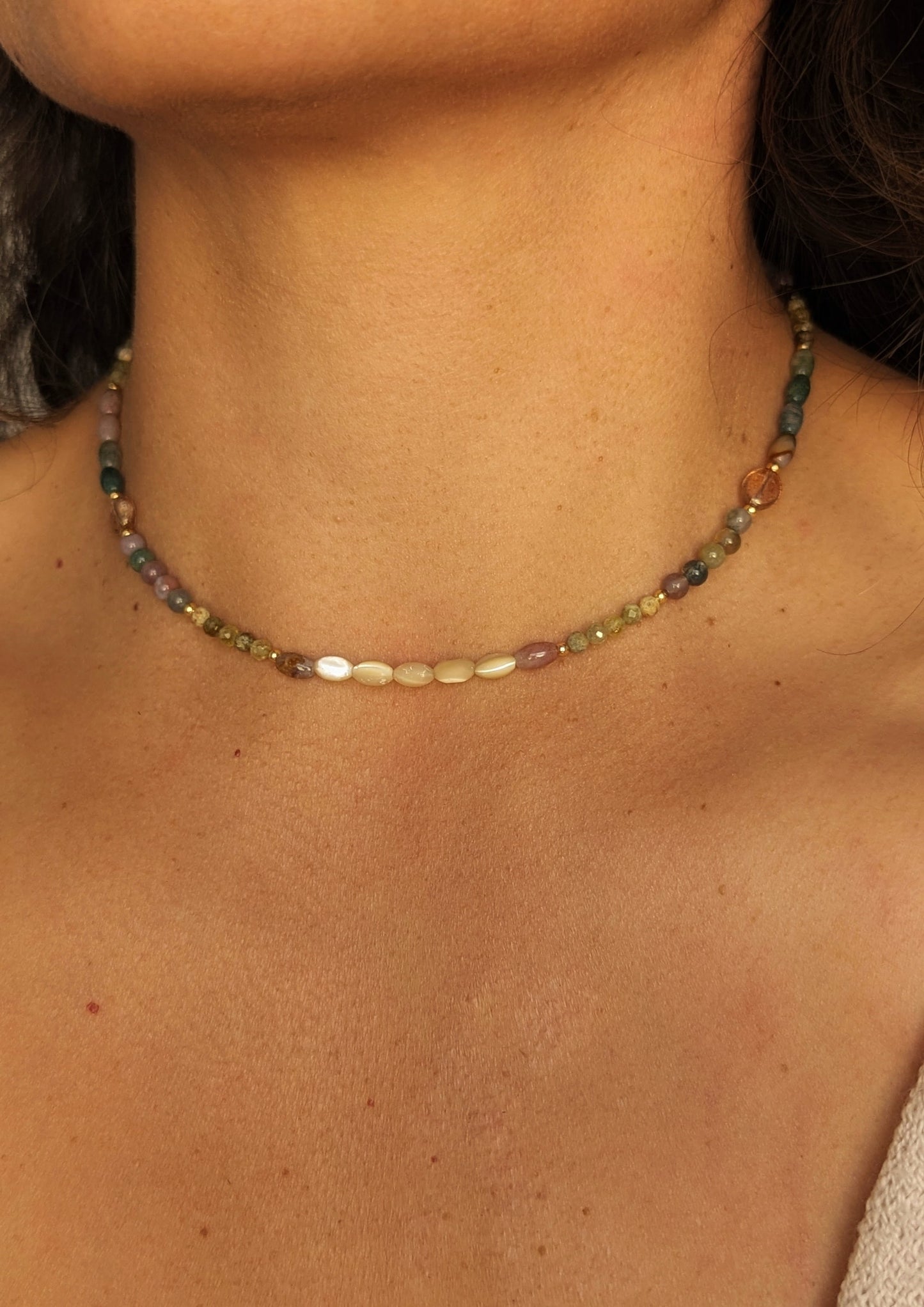 Gemstone necklace choker with multicolored agate beads worn by a person.