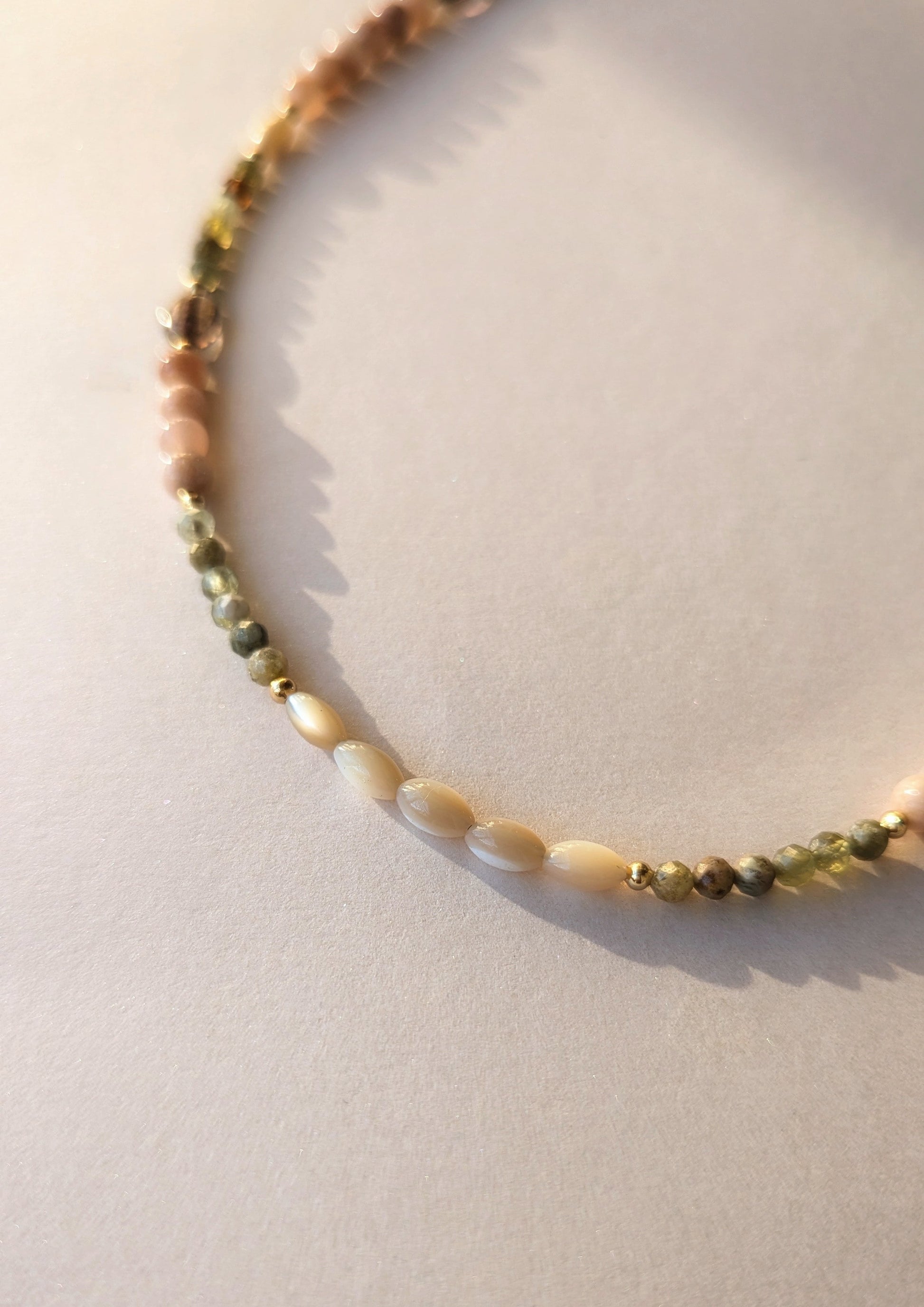 Mother of pearl beaded necklace on a light background.