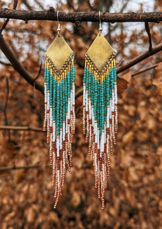 Handcrafted Moon & Milk earrings with turquoise, white, and crimson beads arranged in a chevron pattern, hanging from brass diamond-shaped findings.